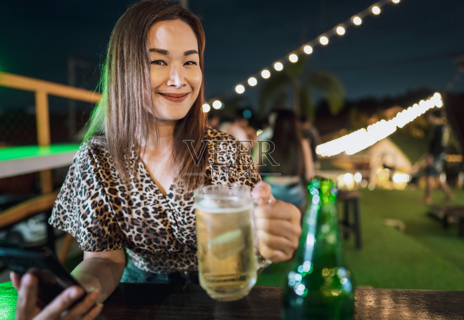 独自坐在户外餐厅喝啤酒的女人照片摄影图片