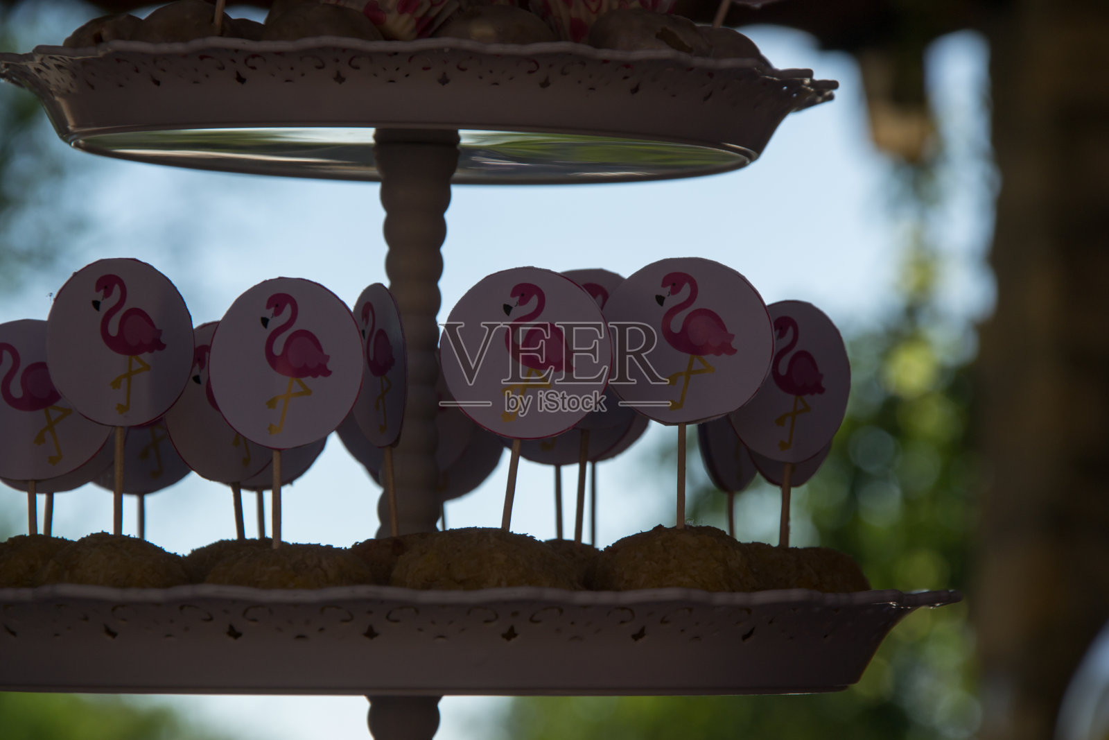 特写自制糖果与粉红色火烈鸟棍棒装饰蛋糕架，派对概念，糖果生日庆祝照片摄影图片