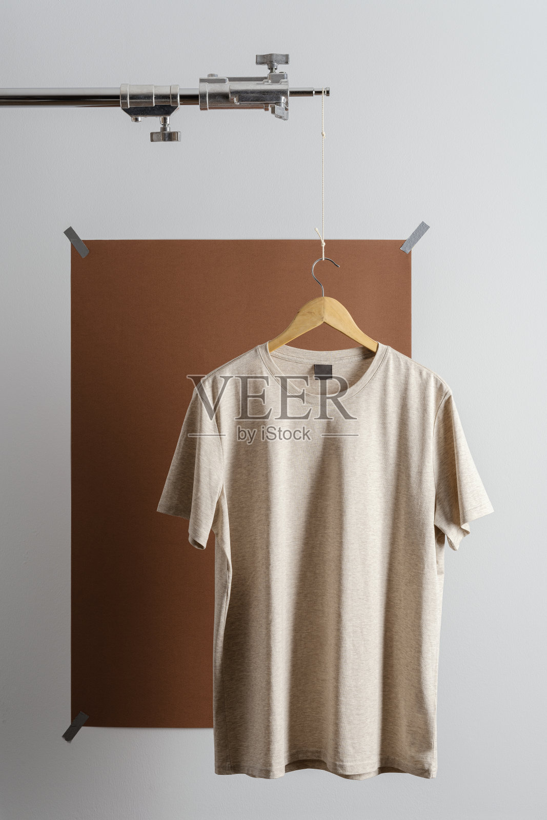米色t恤放在照片三脚架上照片摄影图片