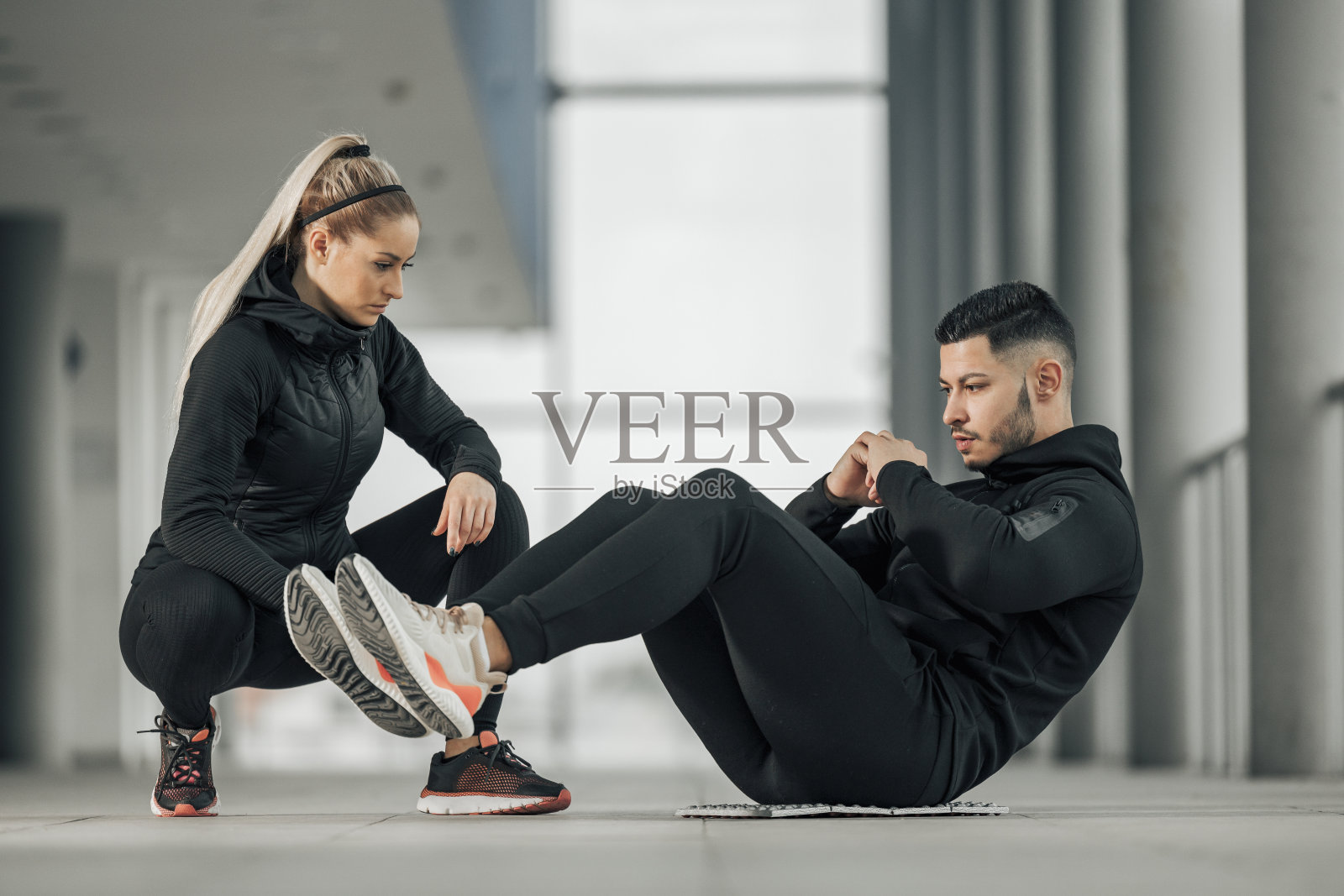 女教练站在他旁边。照片摄影图片