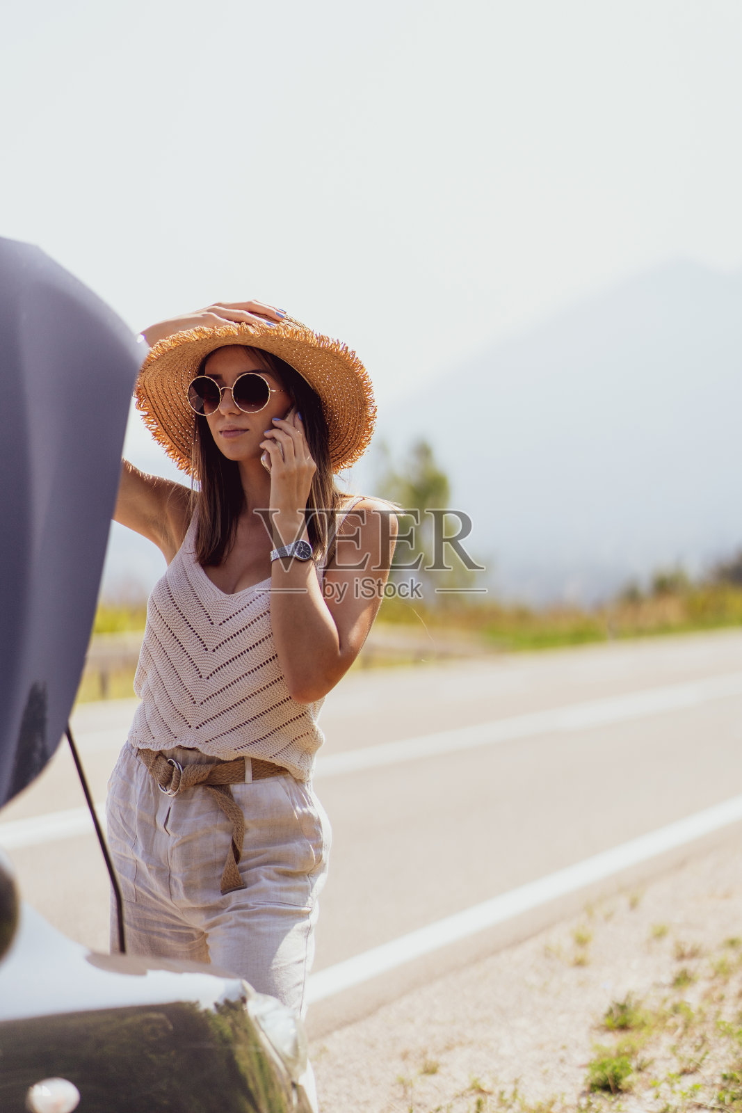 女人站在车旁，呼叫路边救援照片摄影图片