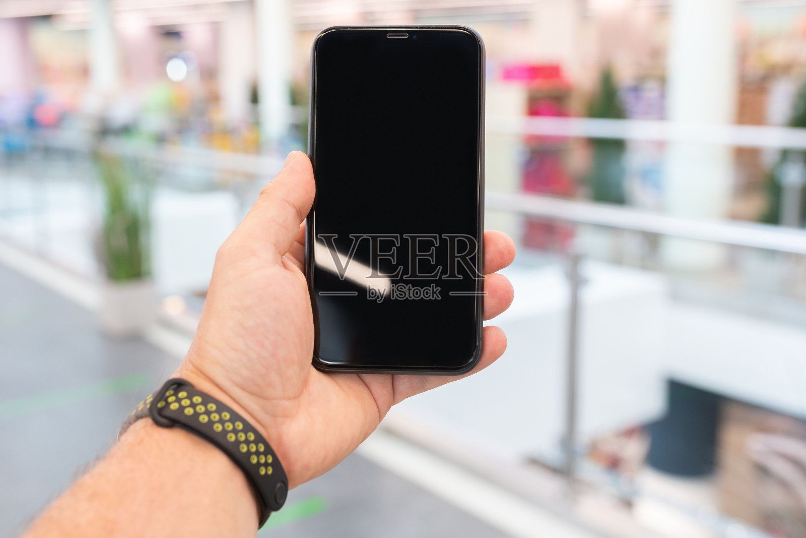 一个男人手里拿着黑屏的智能手机照片摄影图片