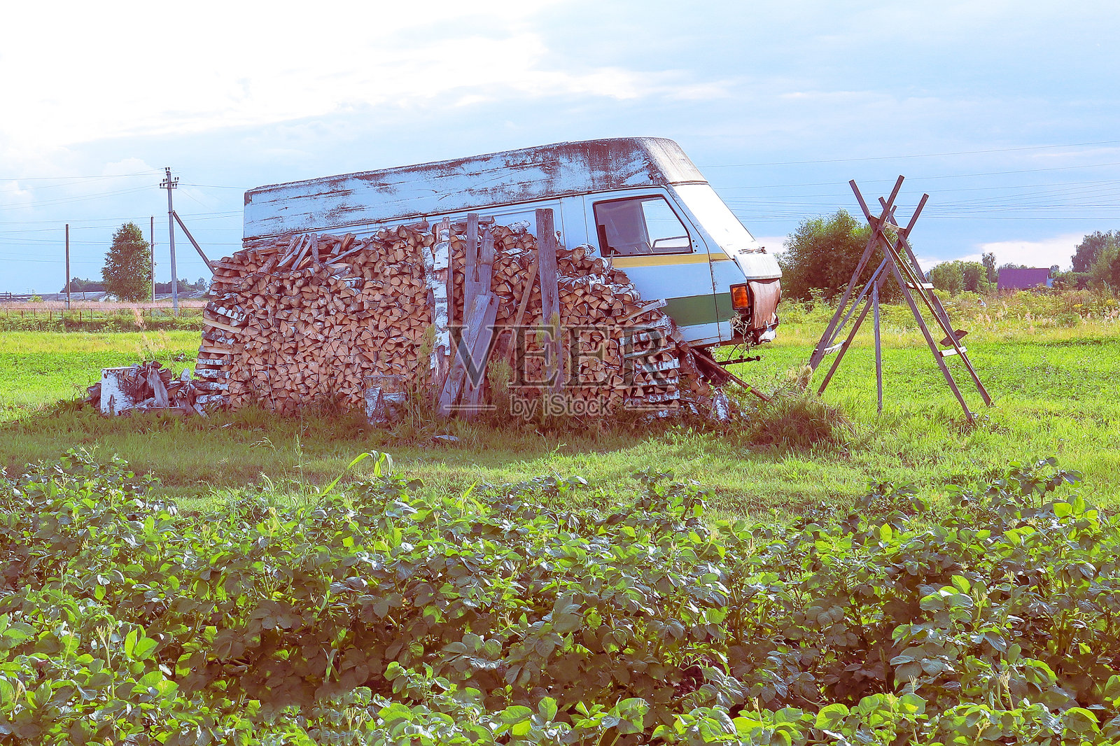 农村景观。汽车旁边有一堆柴火。照片摄影图片