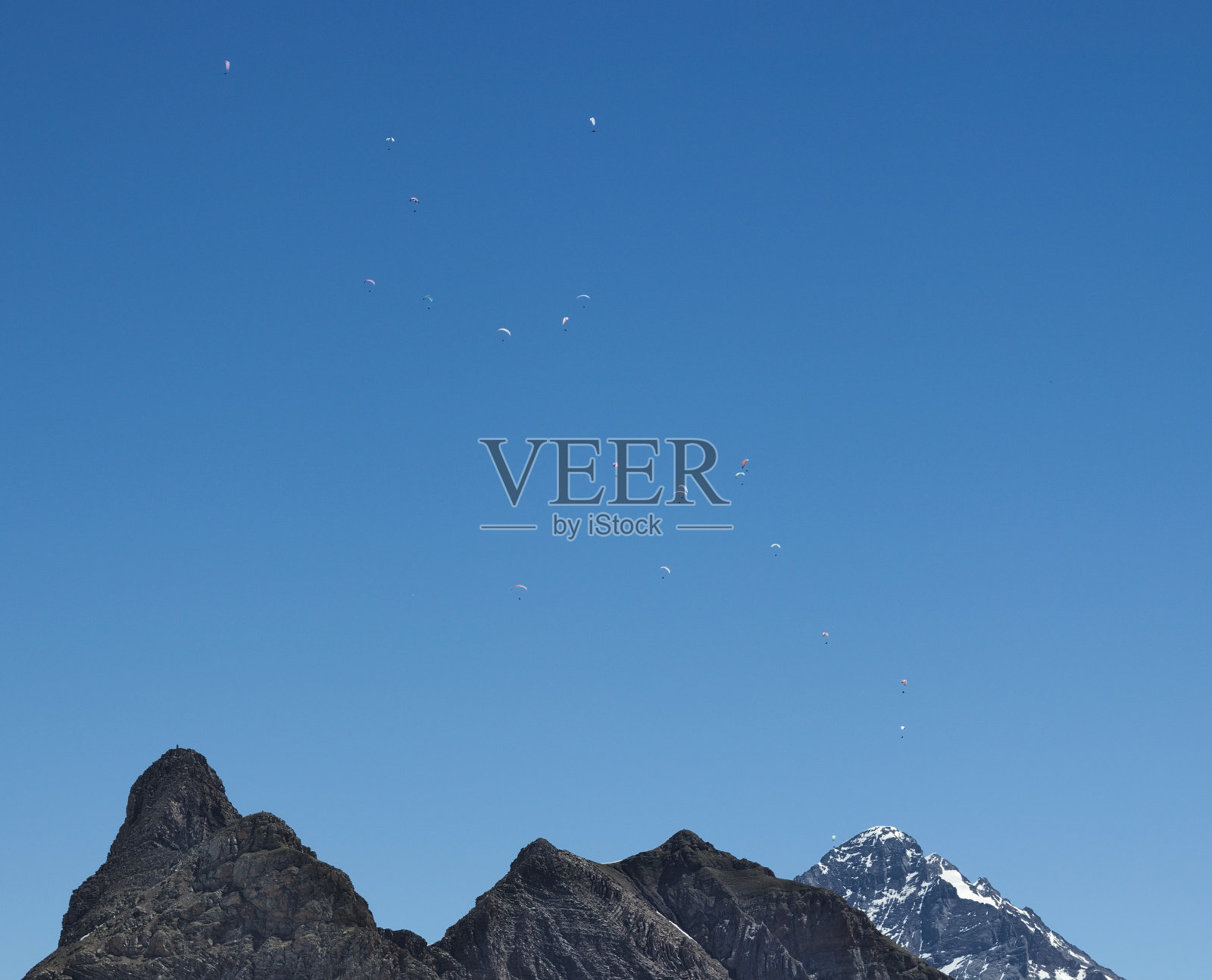 许多滑翔伞上鲜艳的降落伞飞行在烟雾弥漫的山谷上方的城市鸟瞰图照片摄影图片