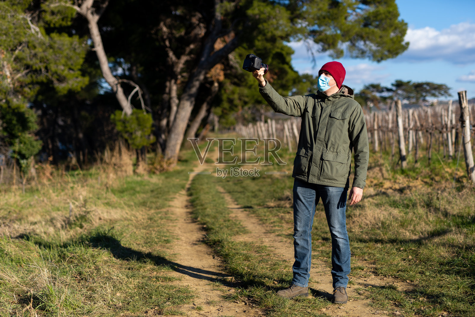年轻人戴着面具在公园里拍视频照片摄影图片