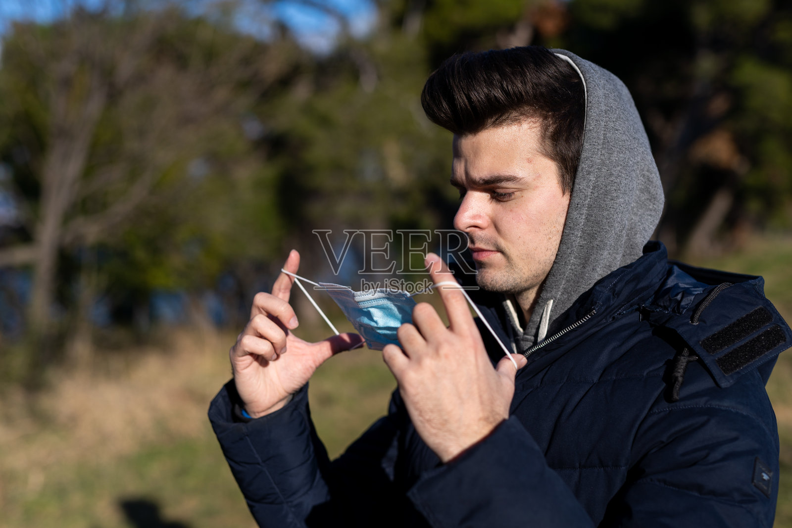 一个年轻人在公园里戴着防护面具的特写照片摄影图片