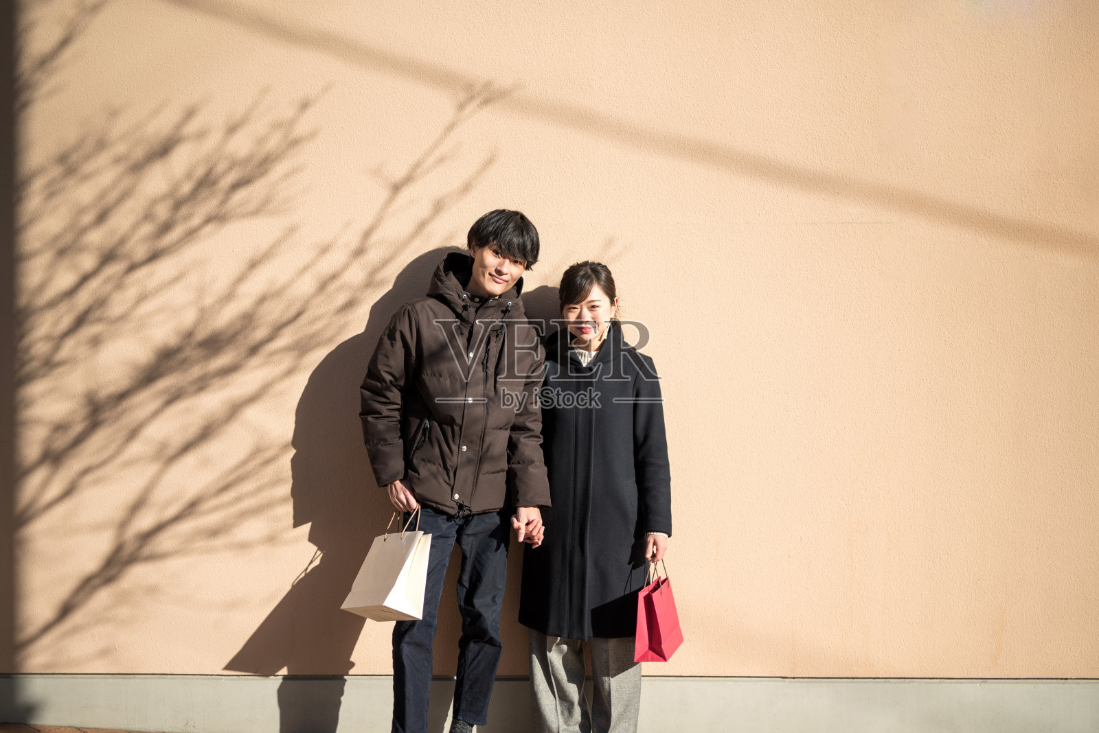 一对倚在墙上的夫妇的肖像照片摄影图片