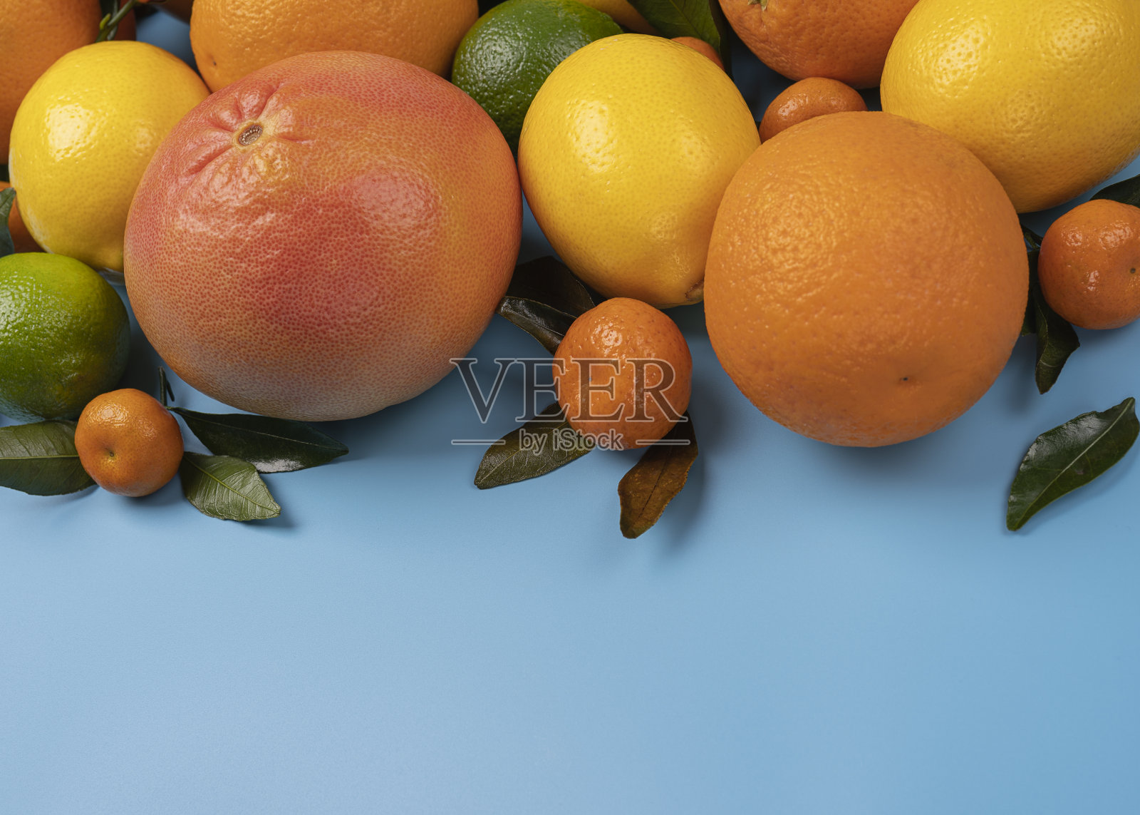 柑橘类水果与叶子在蓝色背景与复制空间照片摄影图片