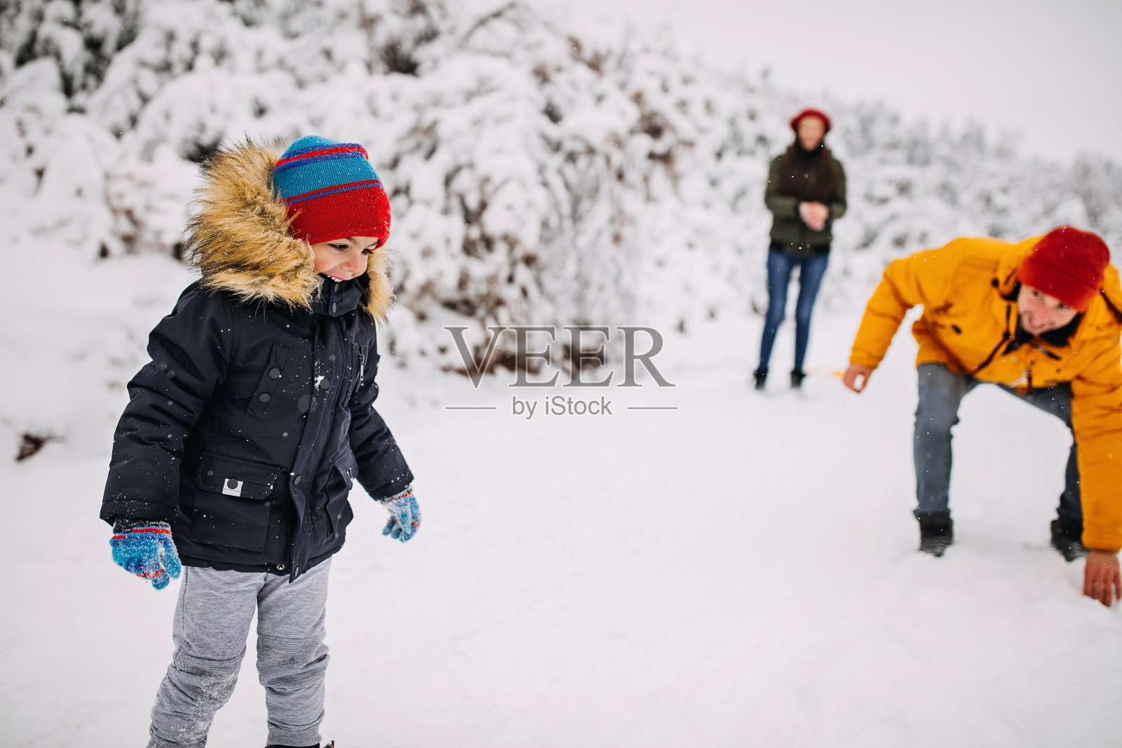 在一个美丽的冬天，年轻快乐的家庭一起在户外玩雪照片摄影图片