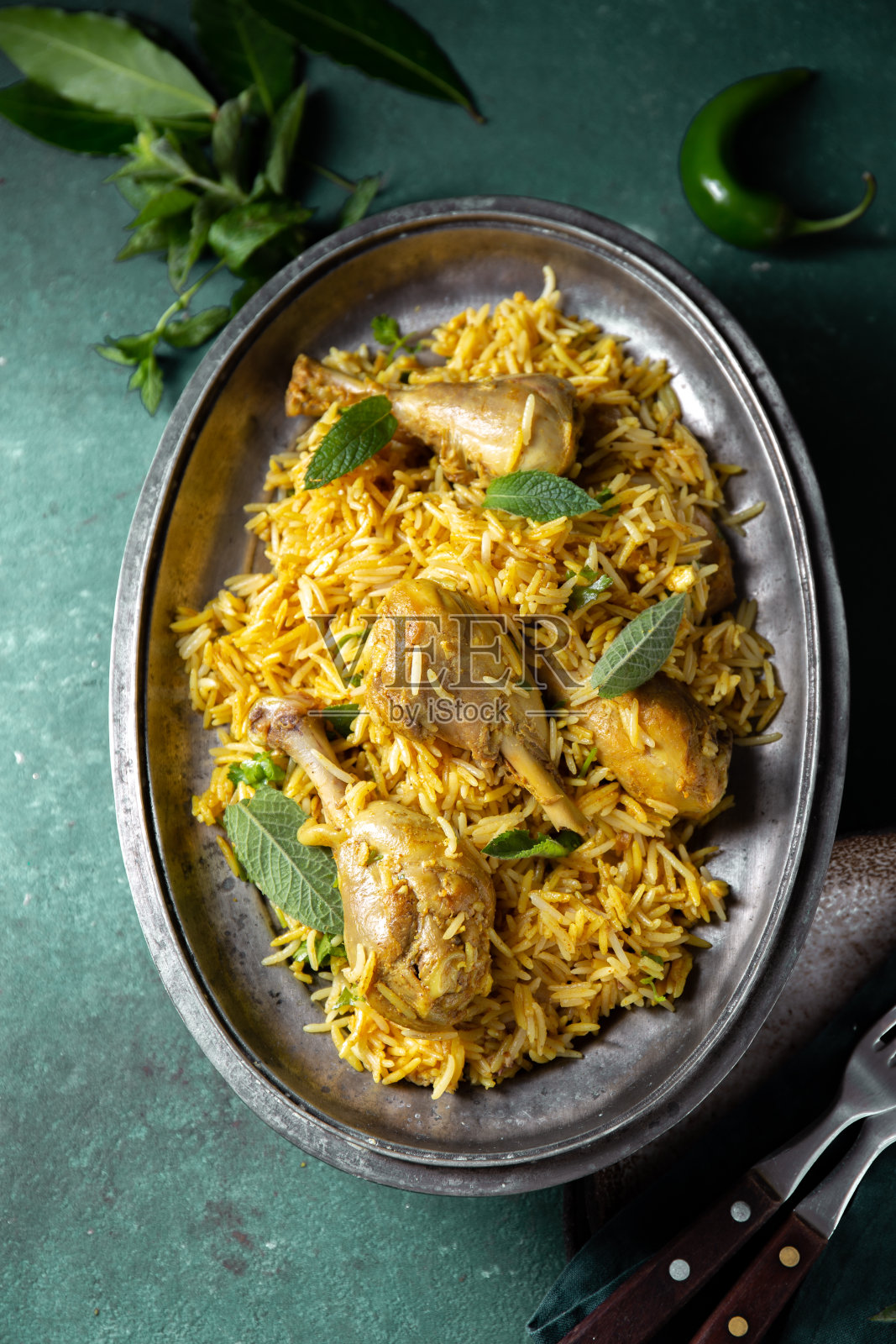 印度或巴基斯坦食物。鸡肉印度饭配薄荷香草和印度烤饼在绿色背景上照片摄影图片