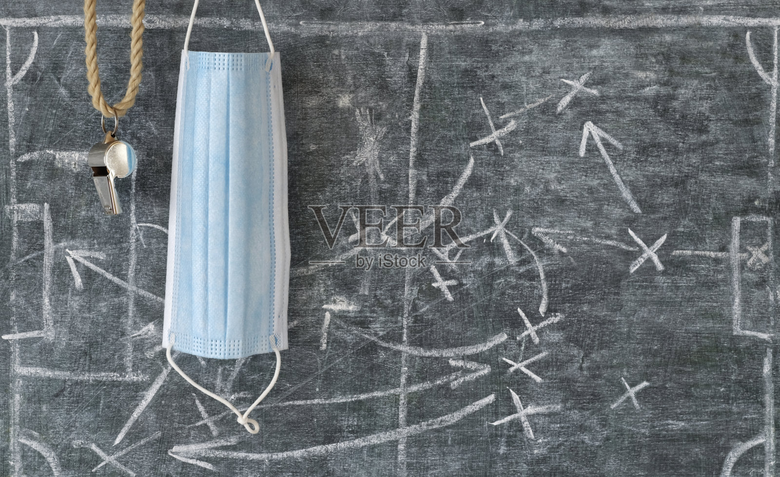 新冠肺炎时期的足球，裁判哨声和带战术图表的黑板书，体育和社交距离概念照片摄影图片