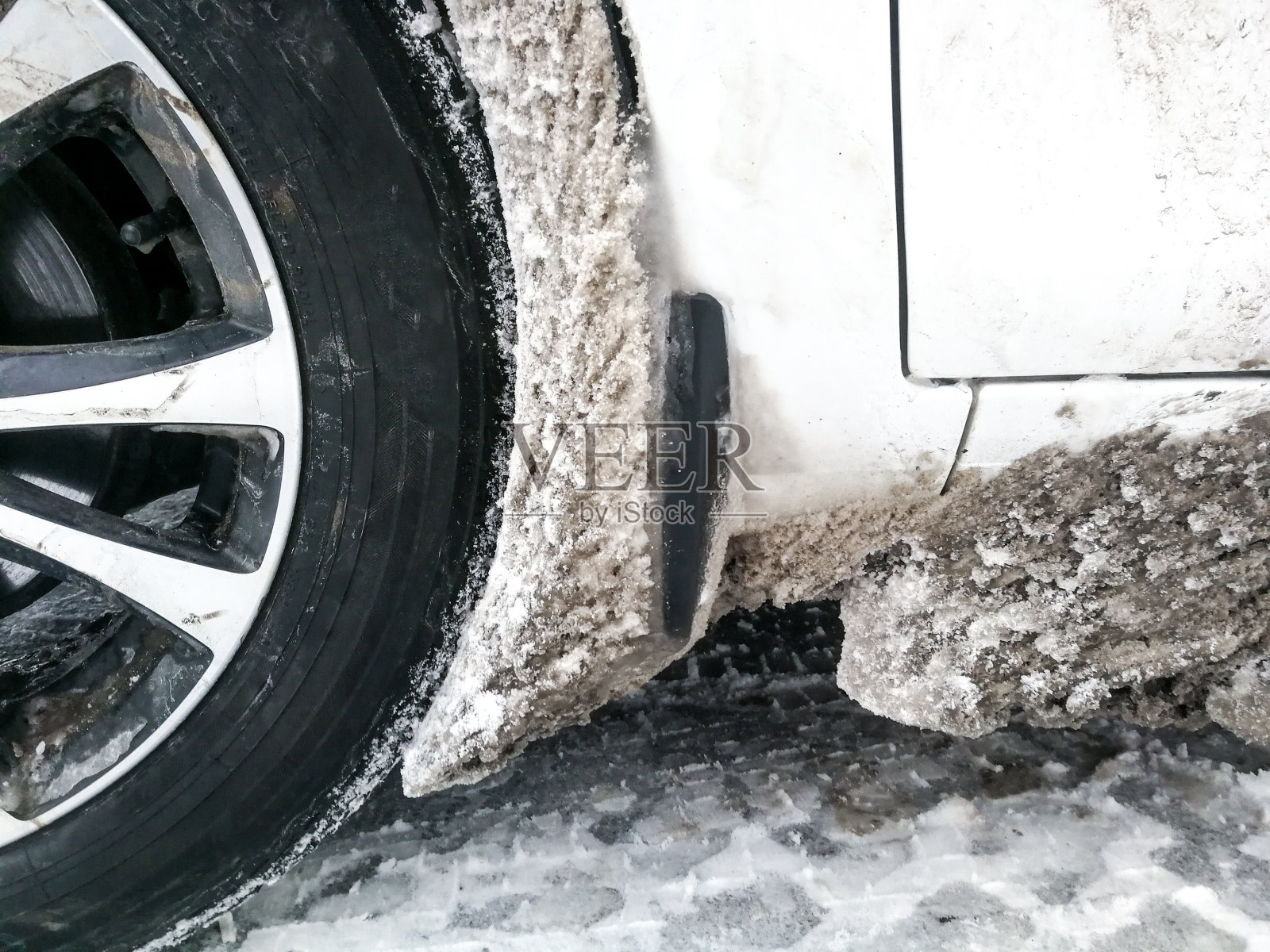 汽车的轮拱被冰雪堵塞了。照片摄影图片