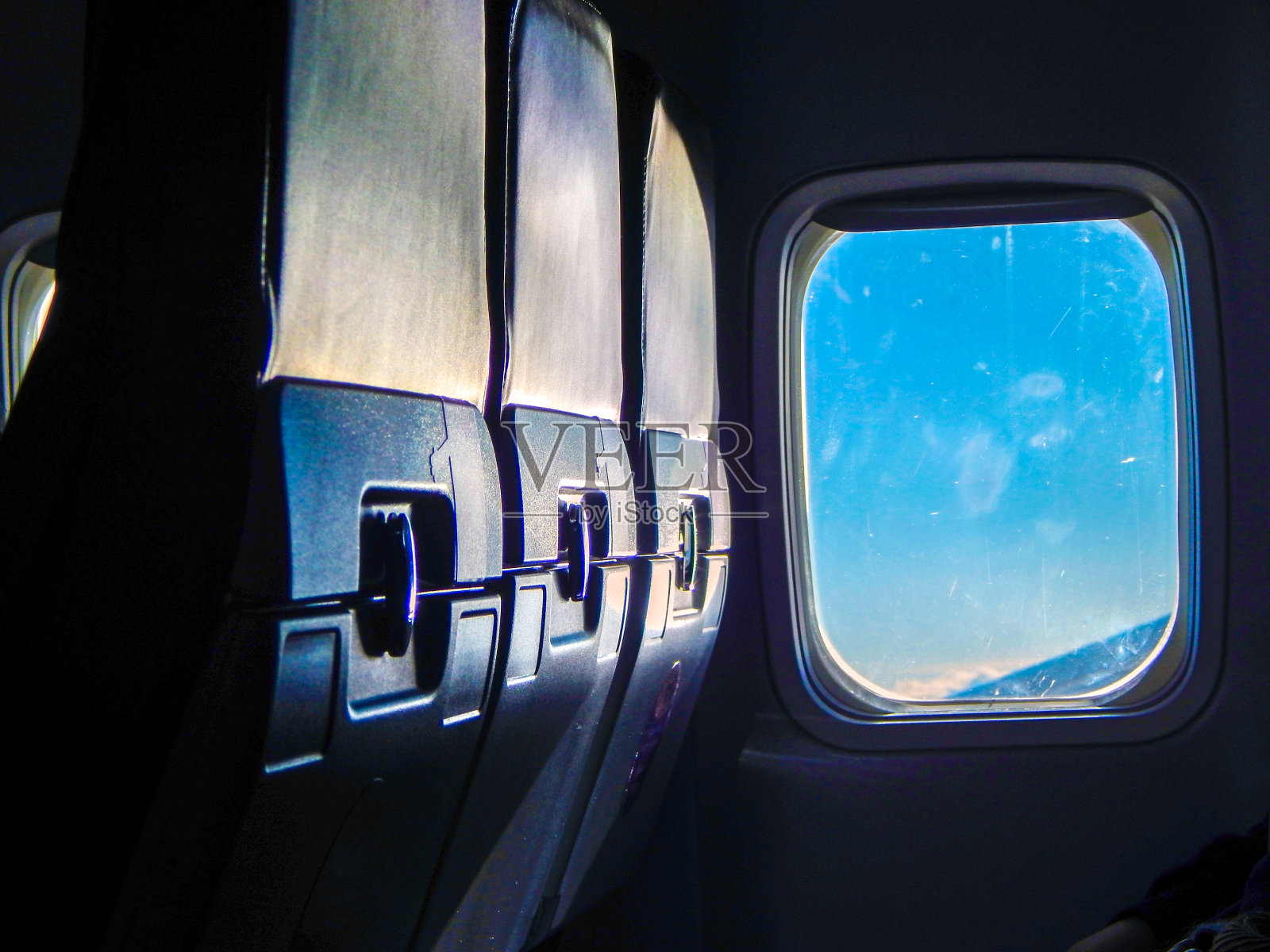 在飞机上靠窗坐成一排的三把椅子照片摄影图片