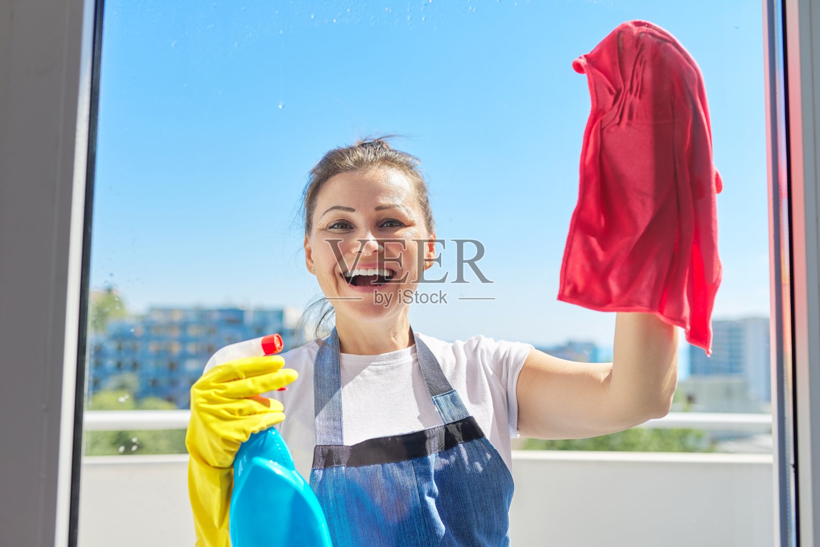 成熟积极的女人洗窗户的肖像照片摄影图片