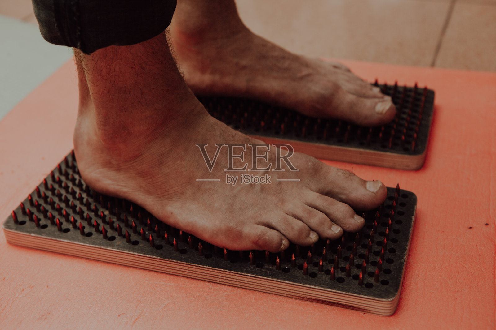 集体练习站在钉子上。特写的瑜伽人站在sadhu板与锋利的钉子。有钉子的苦行木板。照片摄影图片