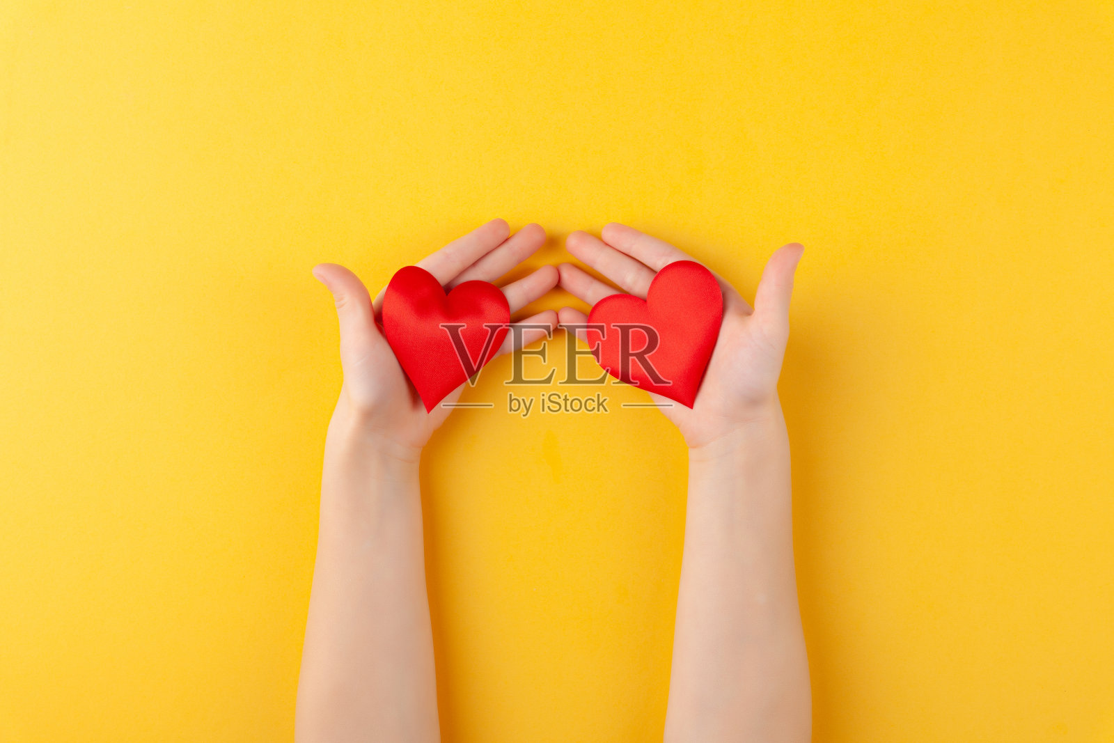 姑娘手里捧着红心、儿女怀抱、爱情和情人节的概念照片摄影图片