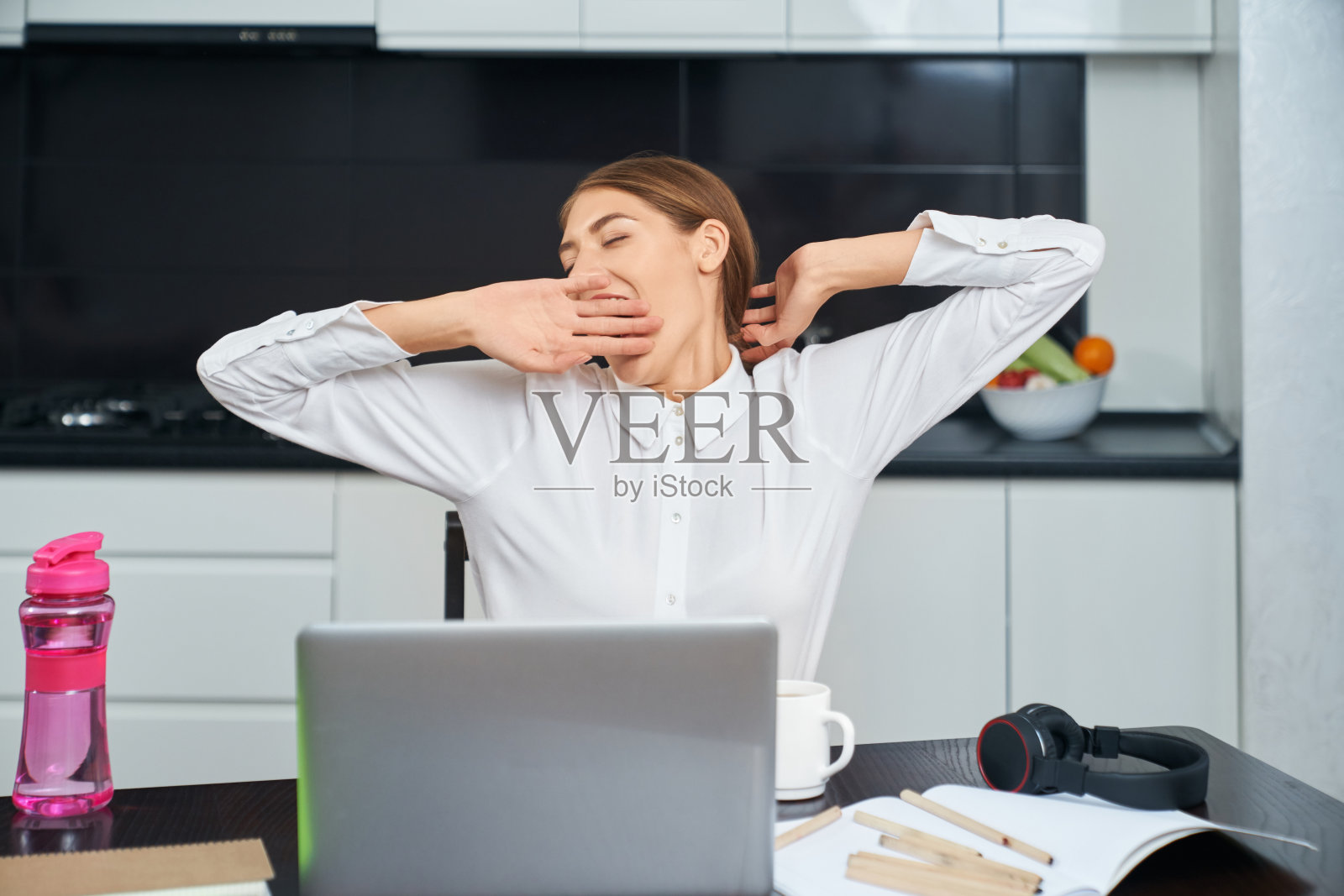 女人在家里工作时伸懒腰打哈欠照片摄影图片