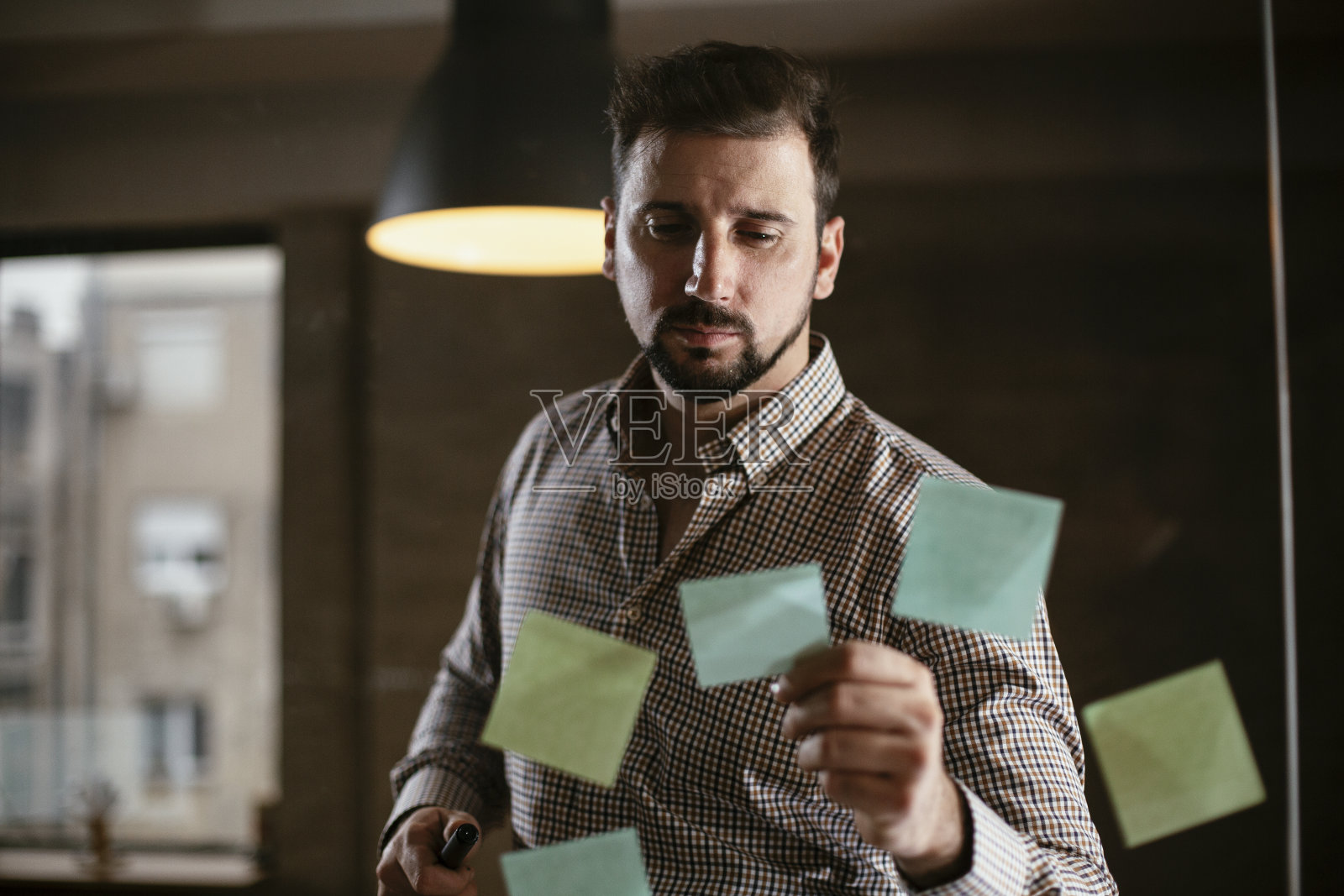 会议室的商人在玻璃墙上使用便利贴。照片摄影图片
