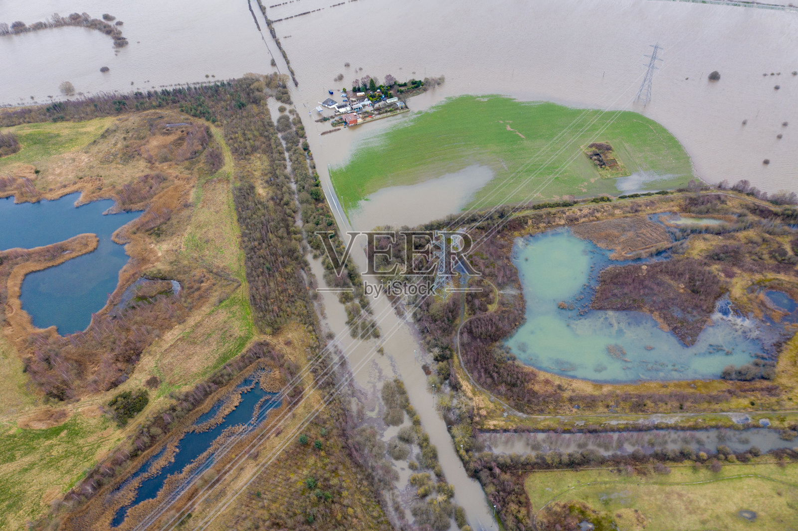 无人机拍摄的小镇阿勒顿Bywater附近的卡斯尔福德在西约克郡利兹，显示了在一场暴风雨后的大洪水中来自埃尔河的被洪水淹没的农田和农舍。照片摄影图片