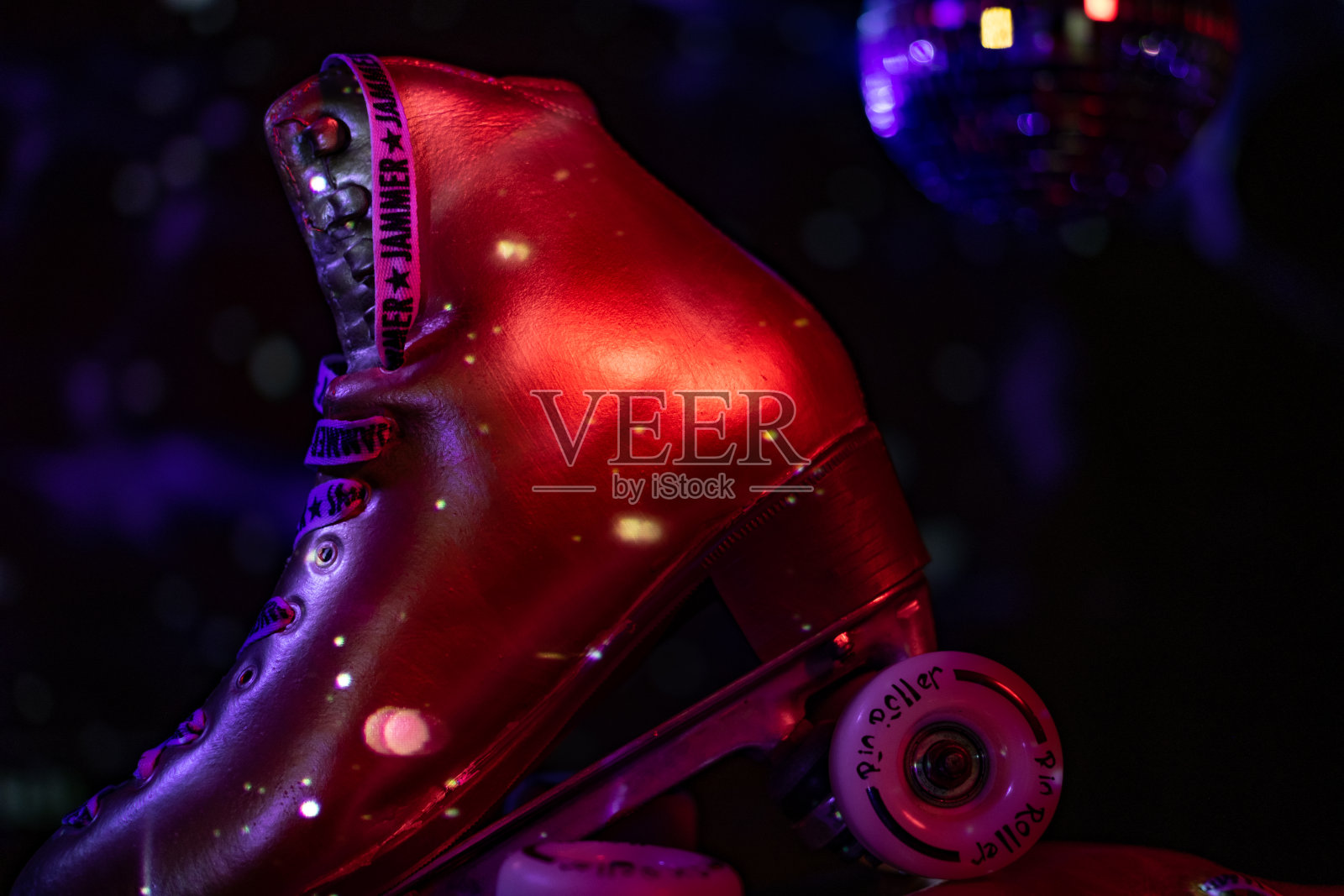 近距离的金色轮滑与迪斯科灯照明。照片摄影图片