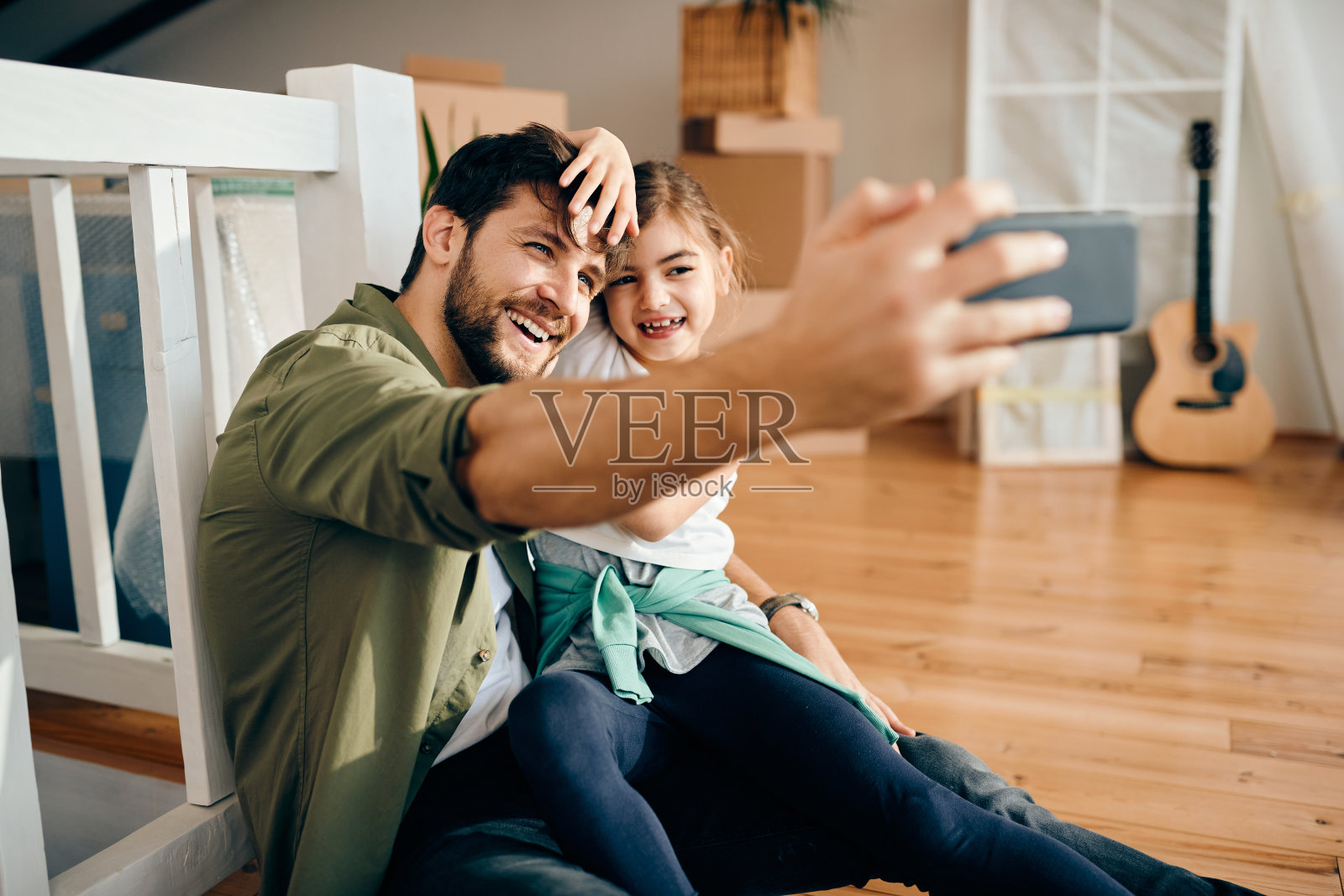 快乐的父女在他们的新公寓里自拍。照片摄影图片