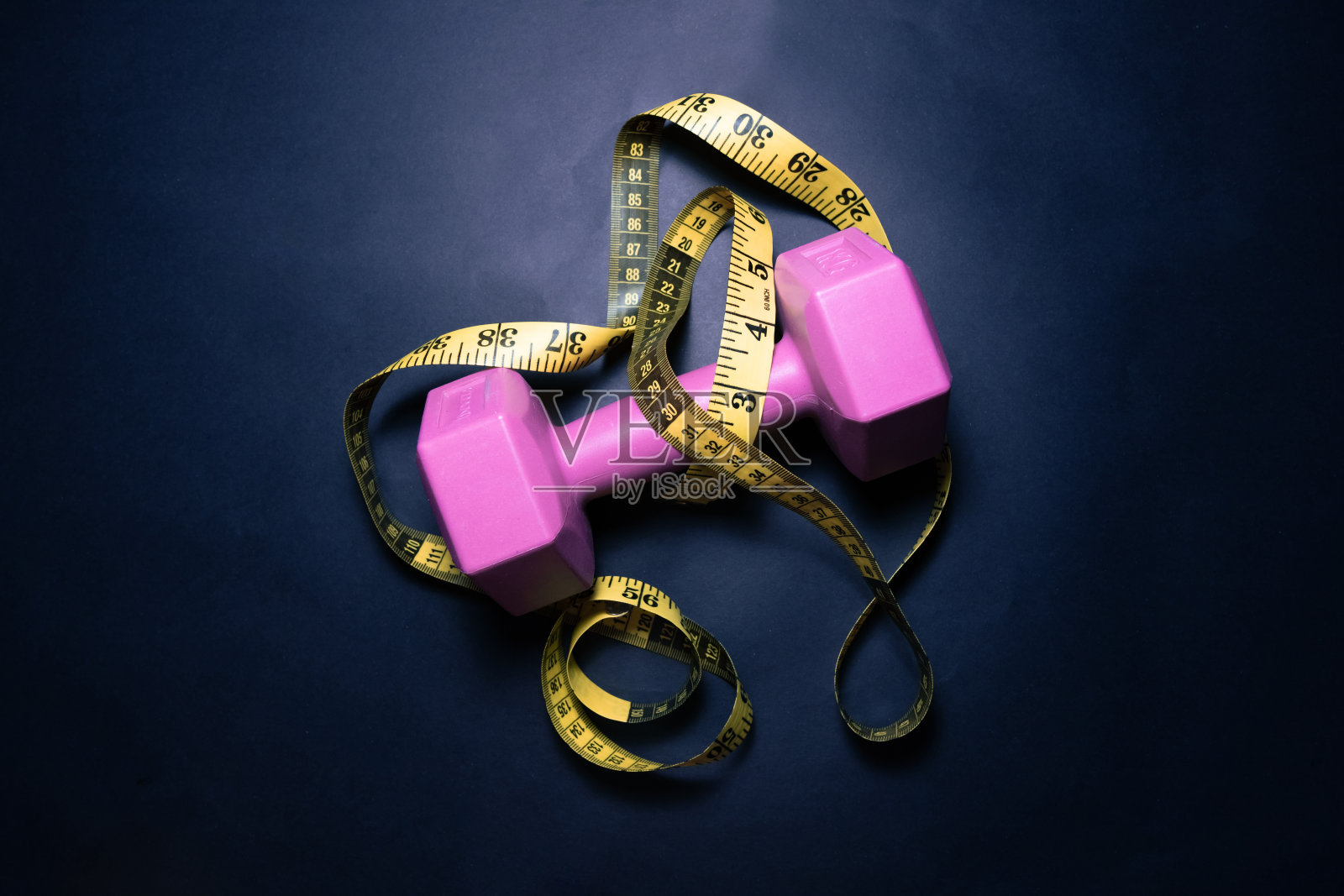 用卷尺叠放健身房重量板照片摄影图片