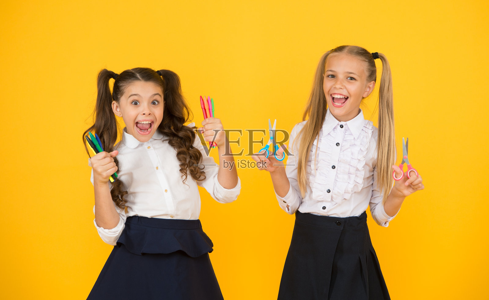 为绘画选择完美的颜色。快乐的孩子们拿着绘画和切割工具。小女孩们用记号笔画画，用剪刀剪东西。绘画课和手工艺的孩子照片摄影图片