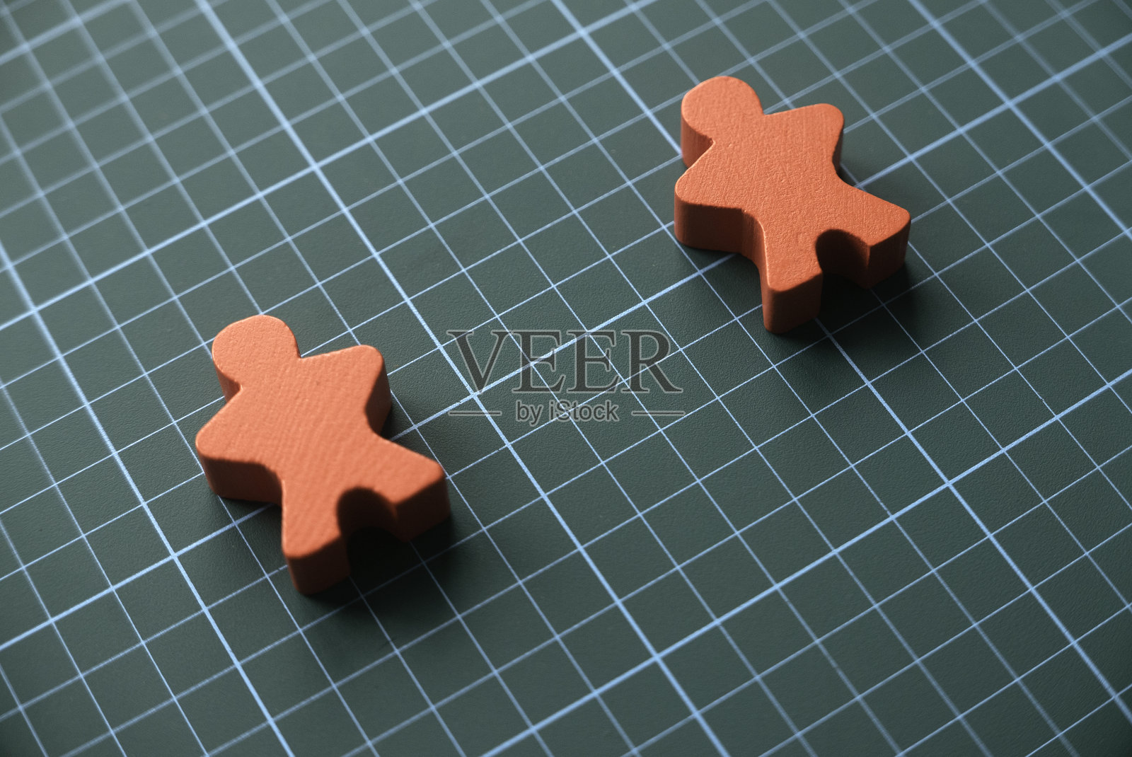 红色木雕人物的选择性焦点代表了冠状病毒或新冠病毒问题的社会距离。社会距离的概念。照片摄影图片