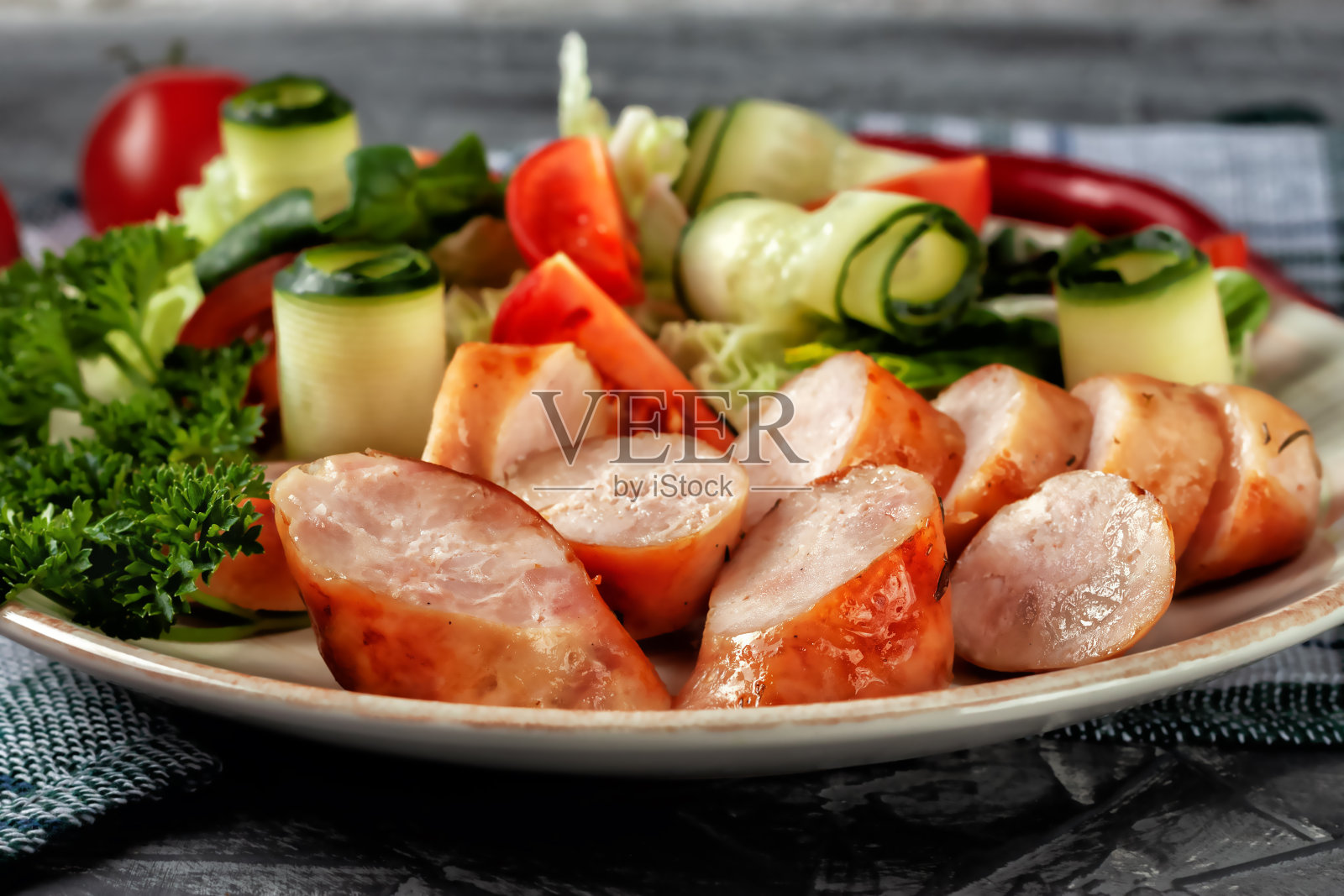 煎制香肠配新鲜蔬菜放在大浅盘上照片摄影图片