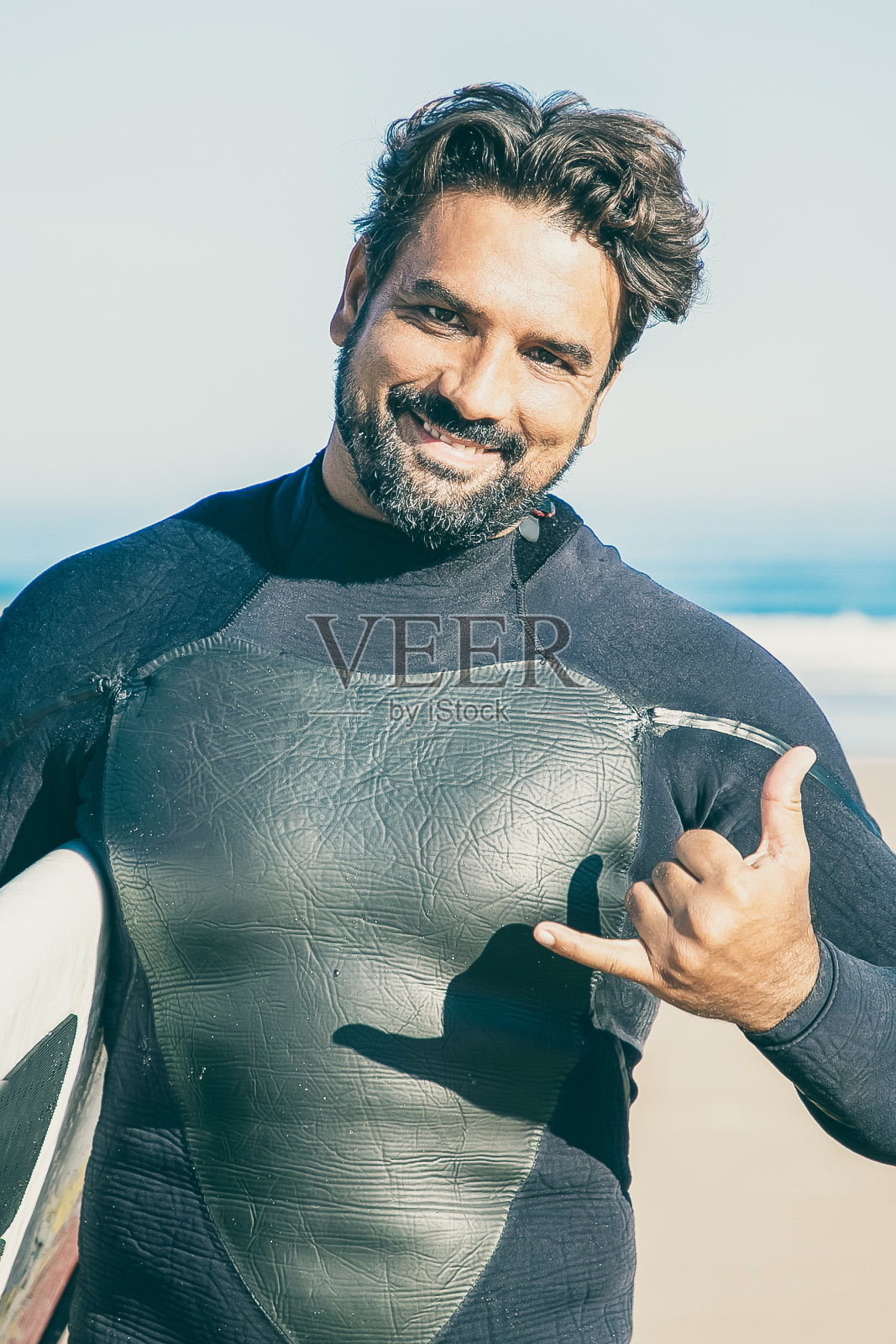 快乐的胡须冲浪者与冲浪板摆姿势的肖像照片摄影图片