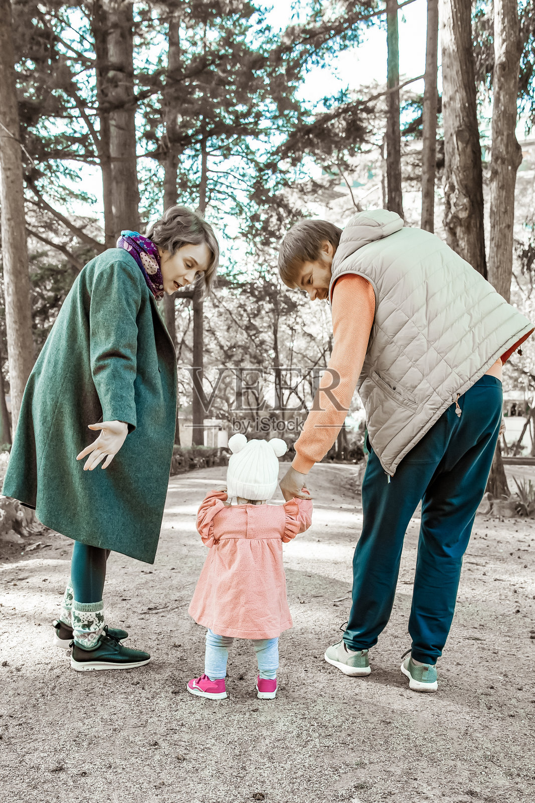 一对家庭夫妇在帮助女婴走路照片摄影图片
