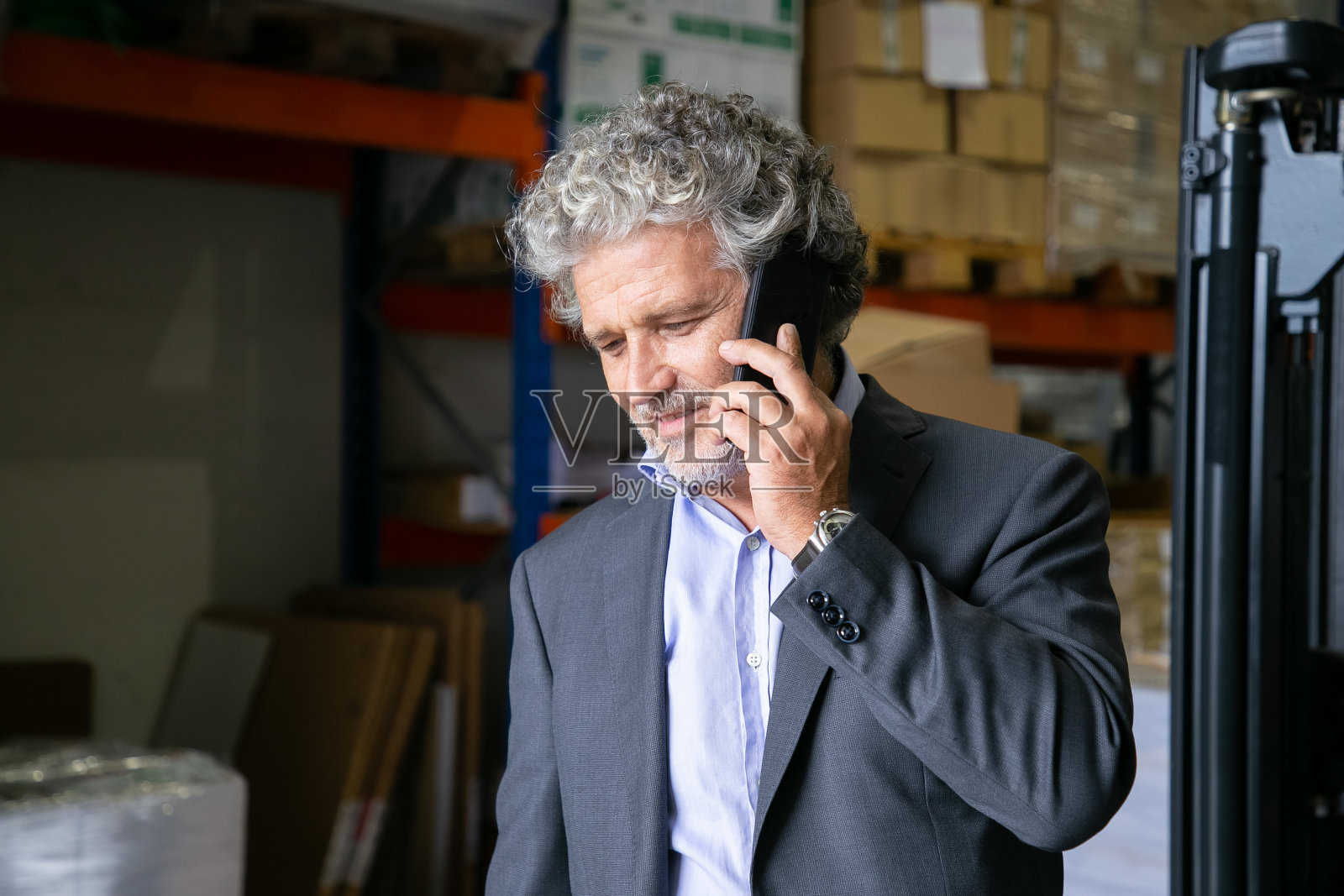 沉思快乐的灰色头发的企业家站在仓库照片摄影图片