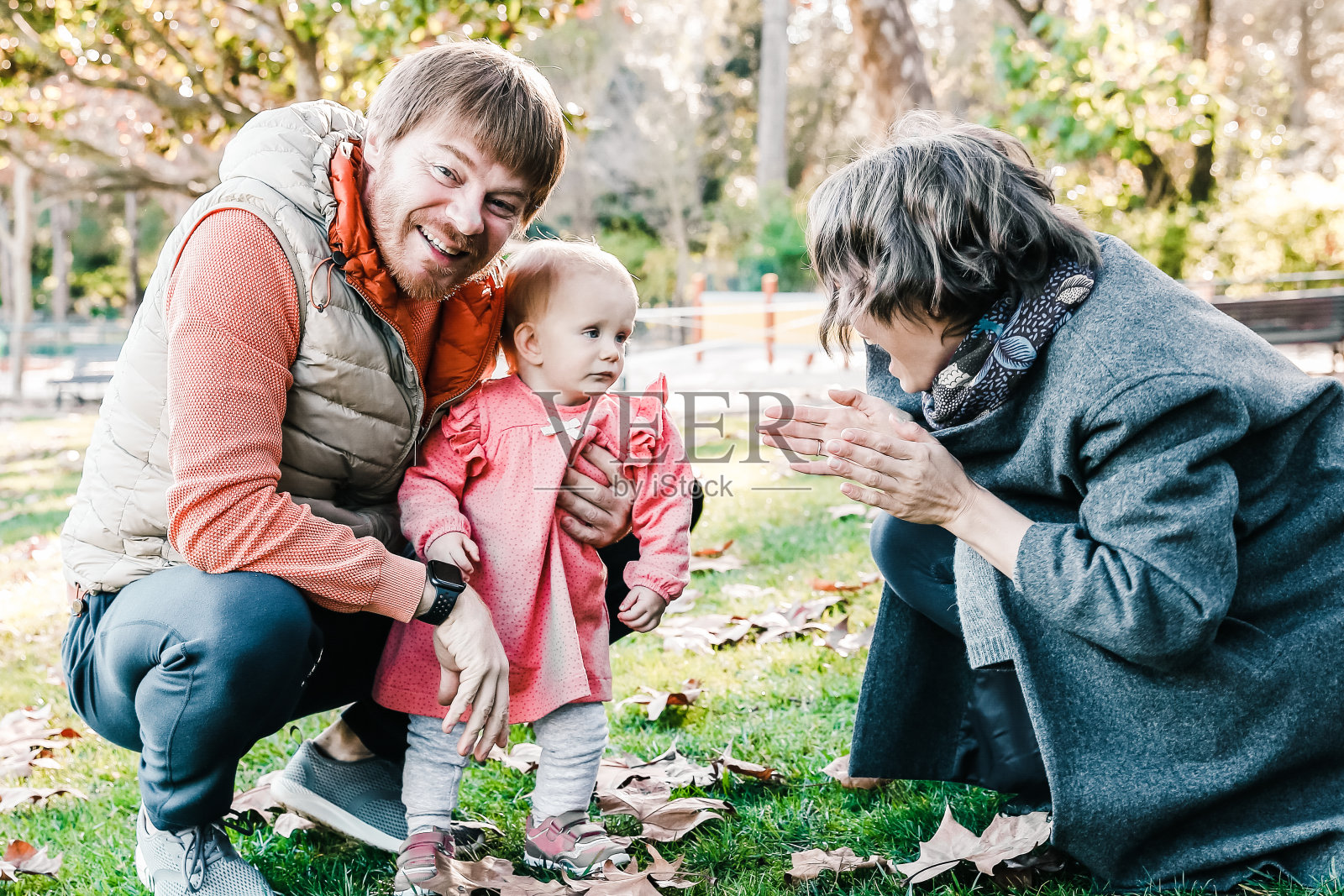 年轻的父母和小孩子在秋天的公园里玩耍照片摄影图片