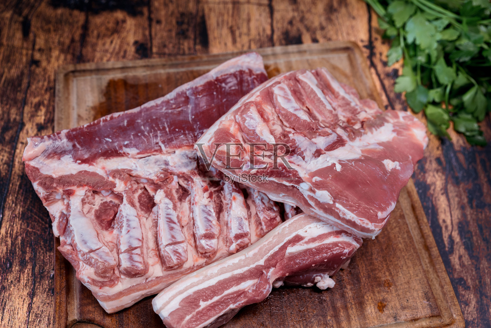 新鲜的五花肉放在旧木桌上的一块用过的砧板上照片摄影图片