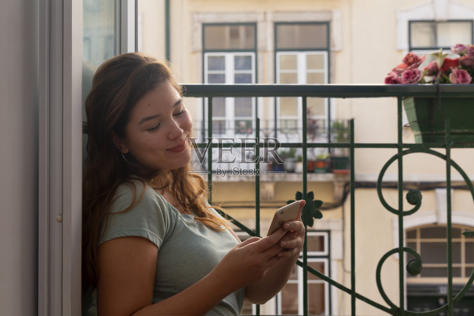 一个年轻女人在阳台附近发短信照片摄影图片