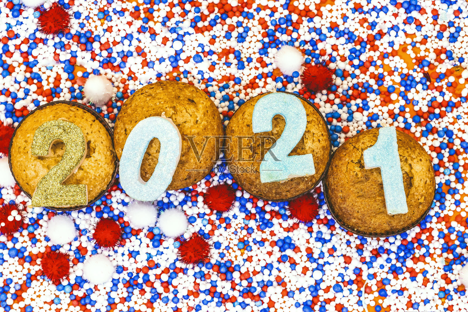 2021年新年蜡烛数字在彩色聚苯乙烯泡沫纸杯蛋糕上照片摄影图片