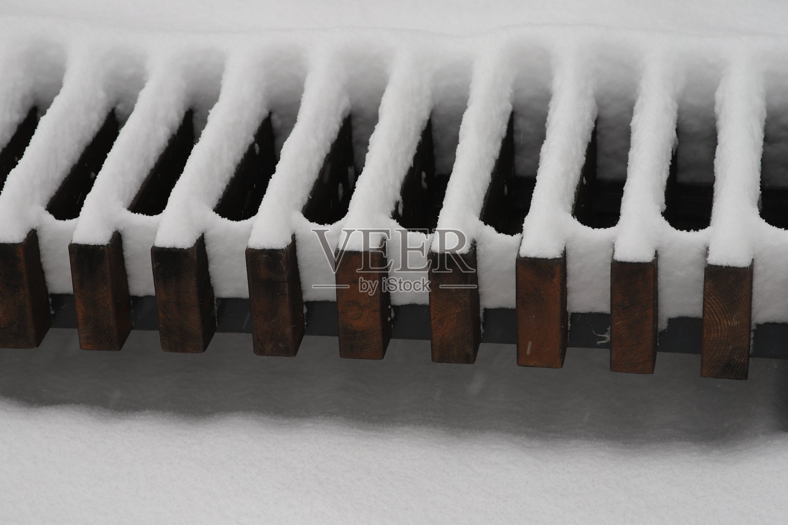 用木头做的长凳，上面覆盖着一层雪照片摄影图片