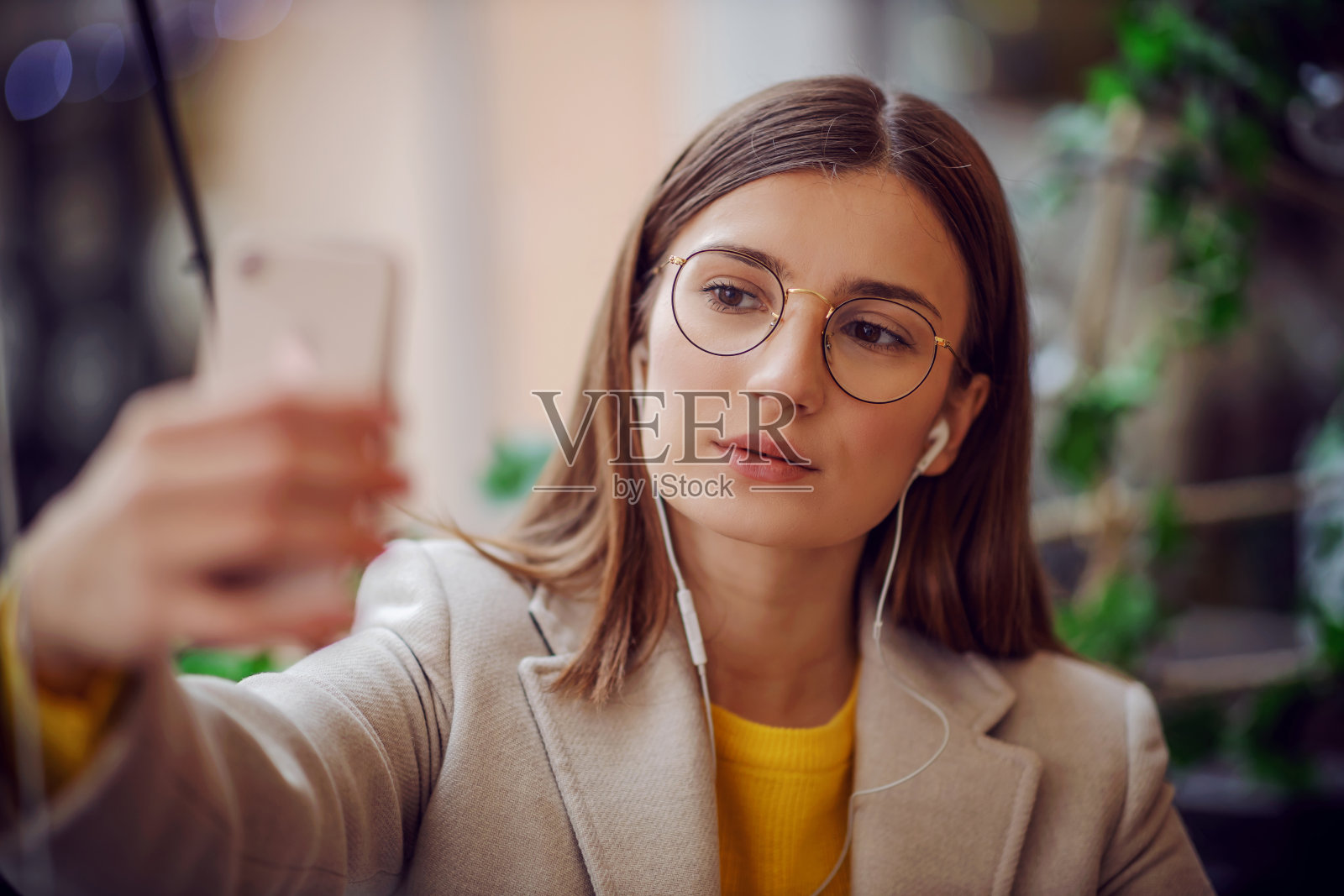 网红们坐在咖啡馆的露台上，戴着耳机拍照留念。照片摄影图片