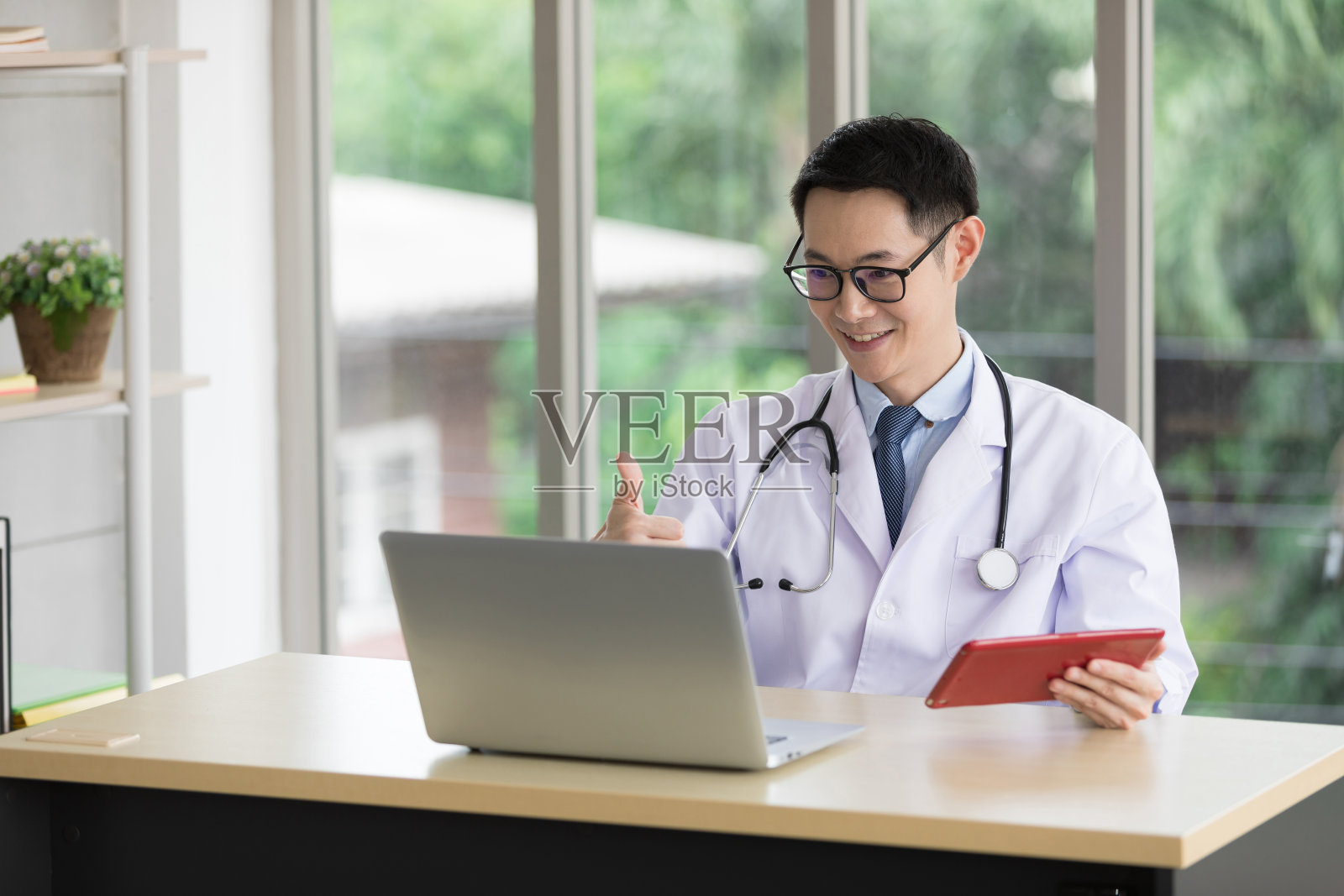 亚洲医生在医院通过电脑与病人或同事进行在线视频聊天照片摄影图片