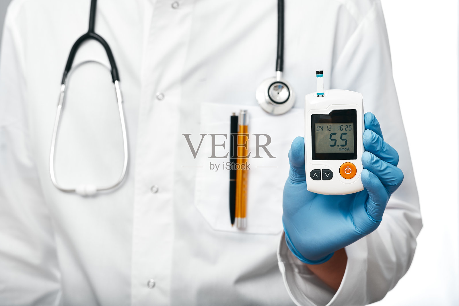 医生拿着血糖仪测量患者血液中的葡萄糖水平，特写照片摄影图片