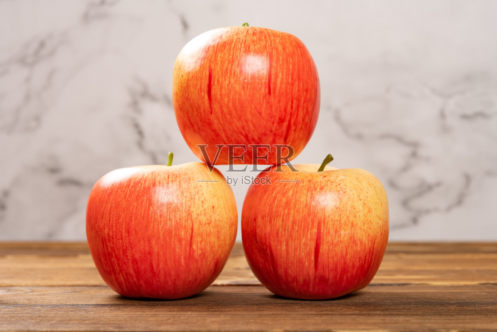 侧视图人造苹果在木桌上照片摄影图片