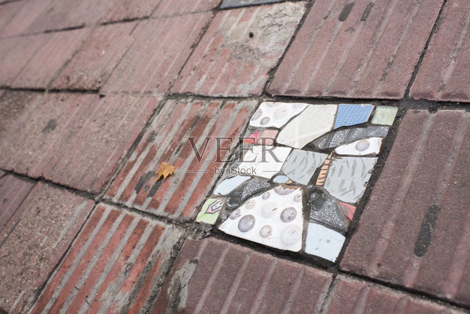 人行道上的瓦片被不同颜色的碎瓦片代替照片摄影图片