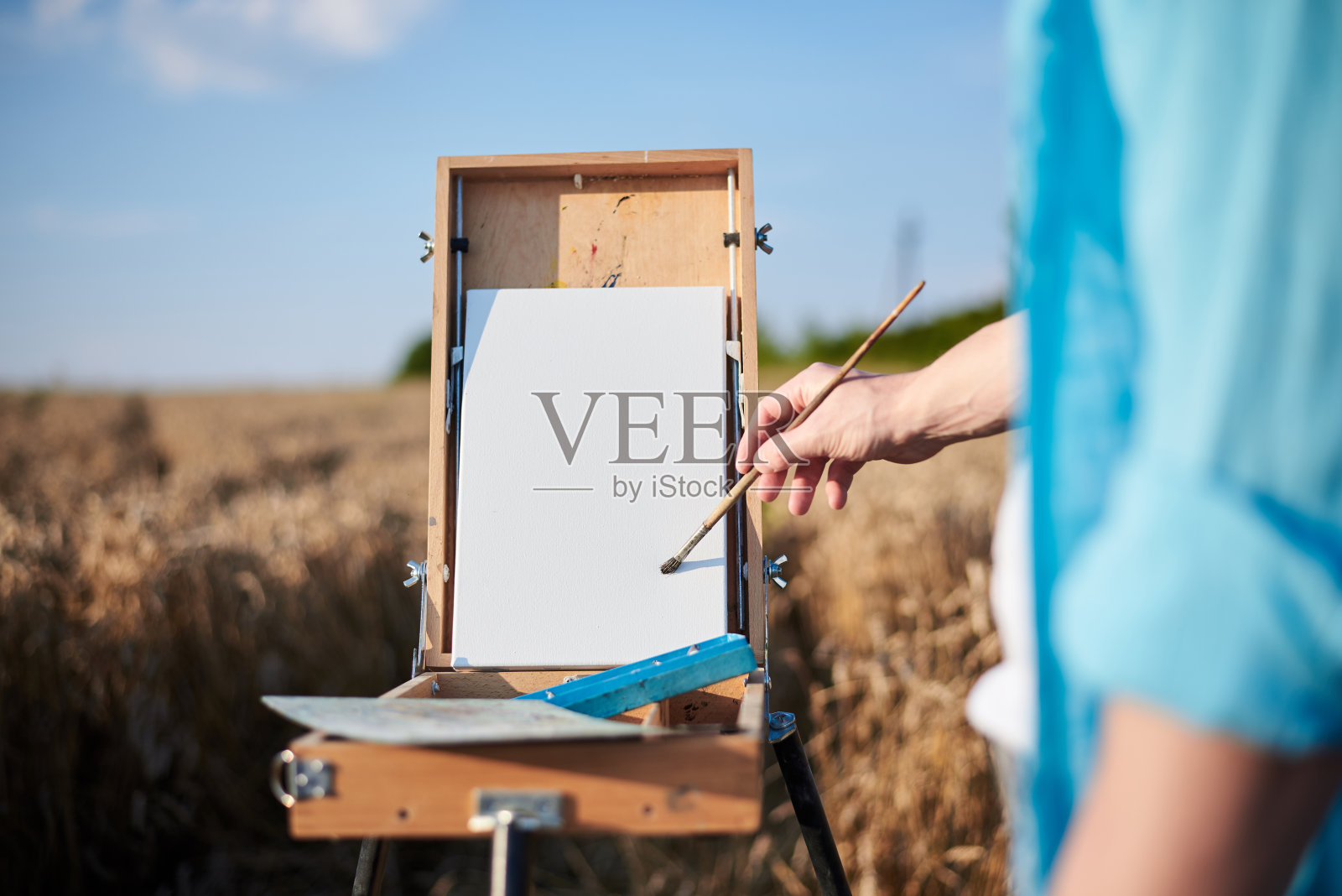 男画家在麦田里作画照片摄影图片