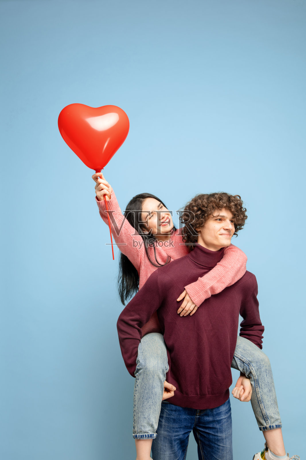 一对美丽的夫妇相爱在蓝色的工作室背景。情人节，爱与情感的概念照片摄影图片