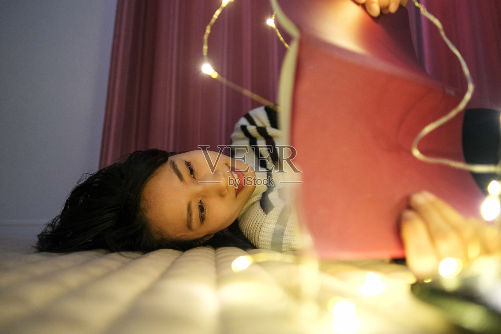 女人晚上在床上看书照片摄影图片