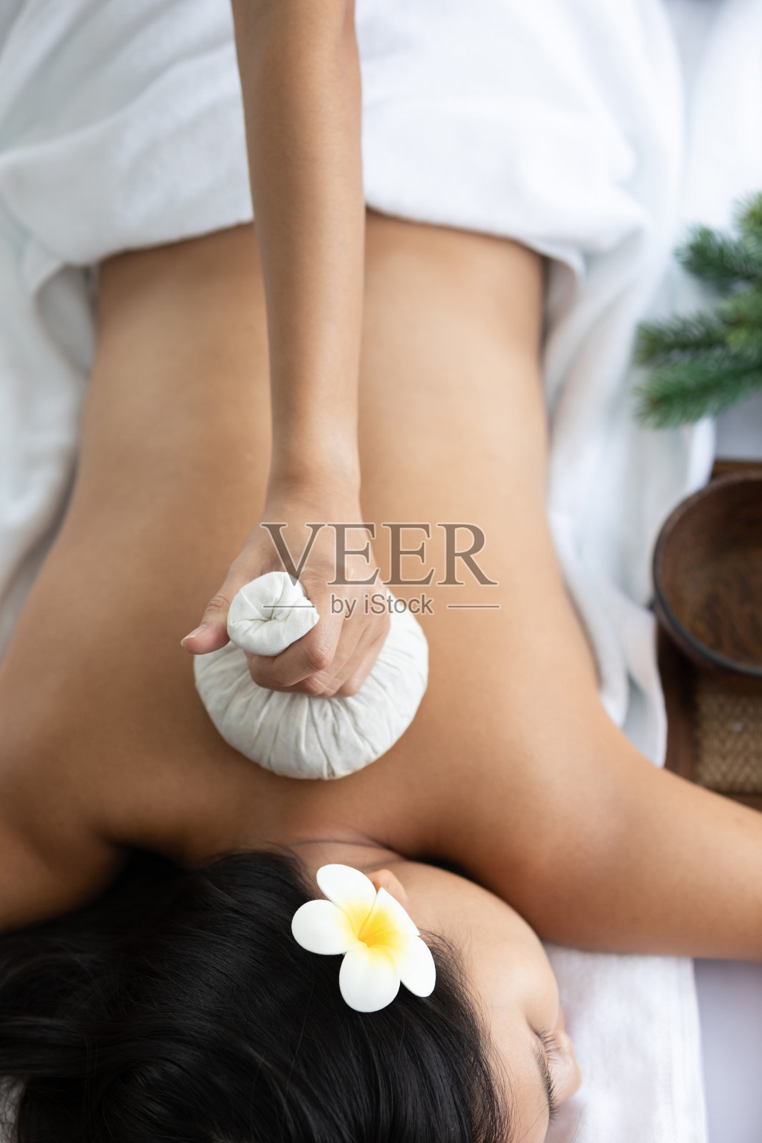 年轻的亚洲美丽的女人享受，睡眠和接受草药球压缩在水疗沙龙的背部照片摄影图片