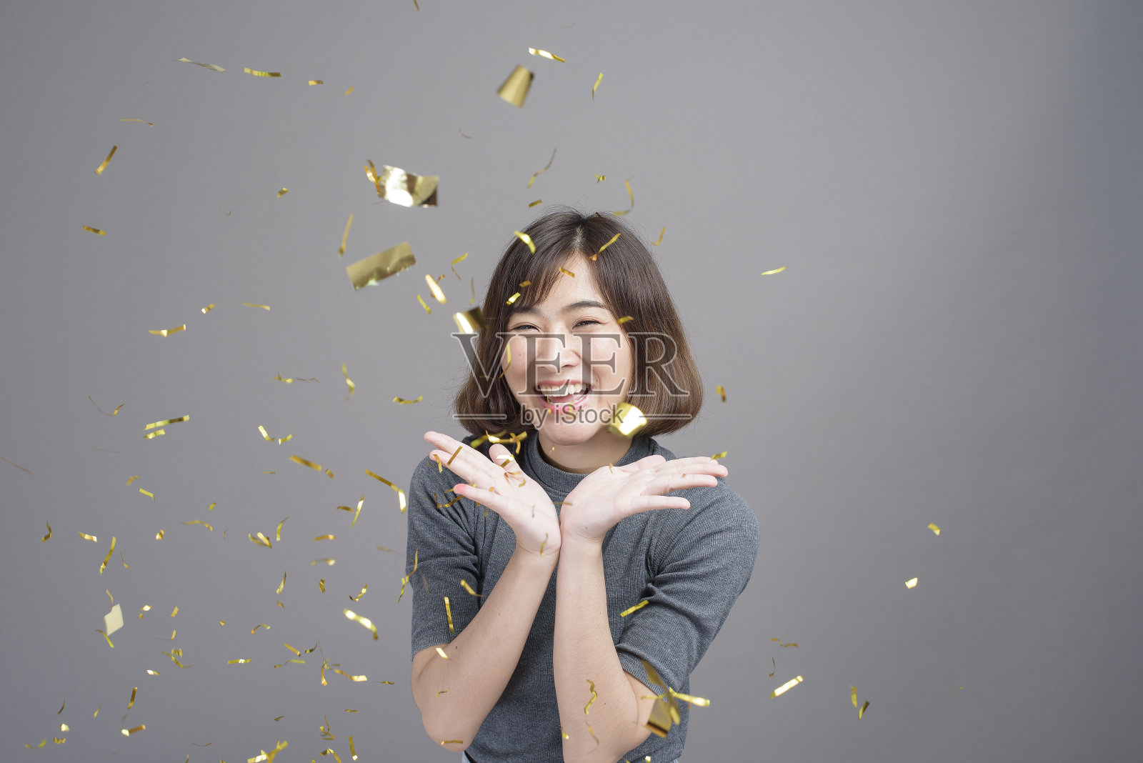 年轻美丽的亚洲女人的肖像庆祝和玩纸拍摄孤立的灰色背景工作室，圣诞节和新年的概念。照片摄影图片