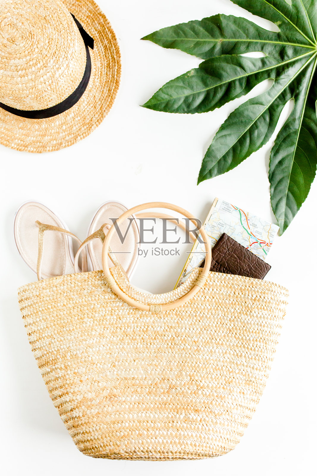 女士沙滩配饰:藤条包，草帽，热带棕榈叶，白色背景。旅行的概念。夏天的背景。平躺,照片摄影图片