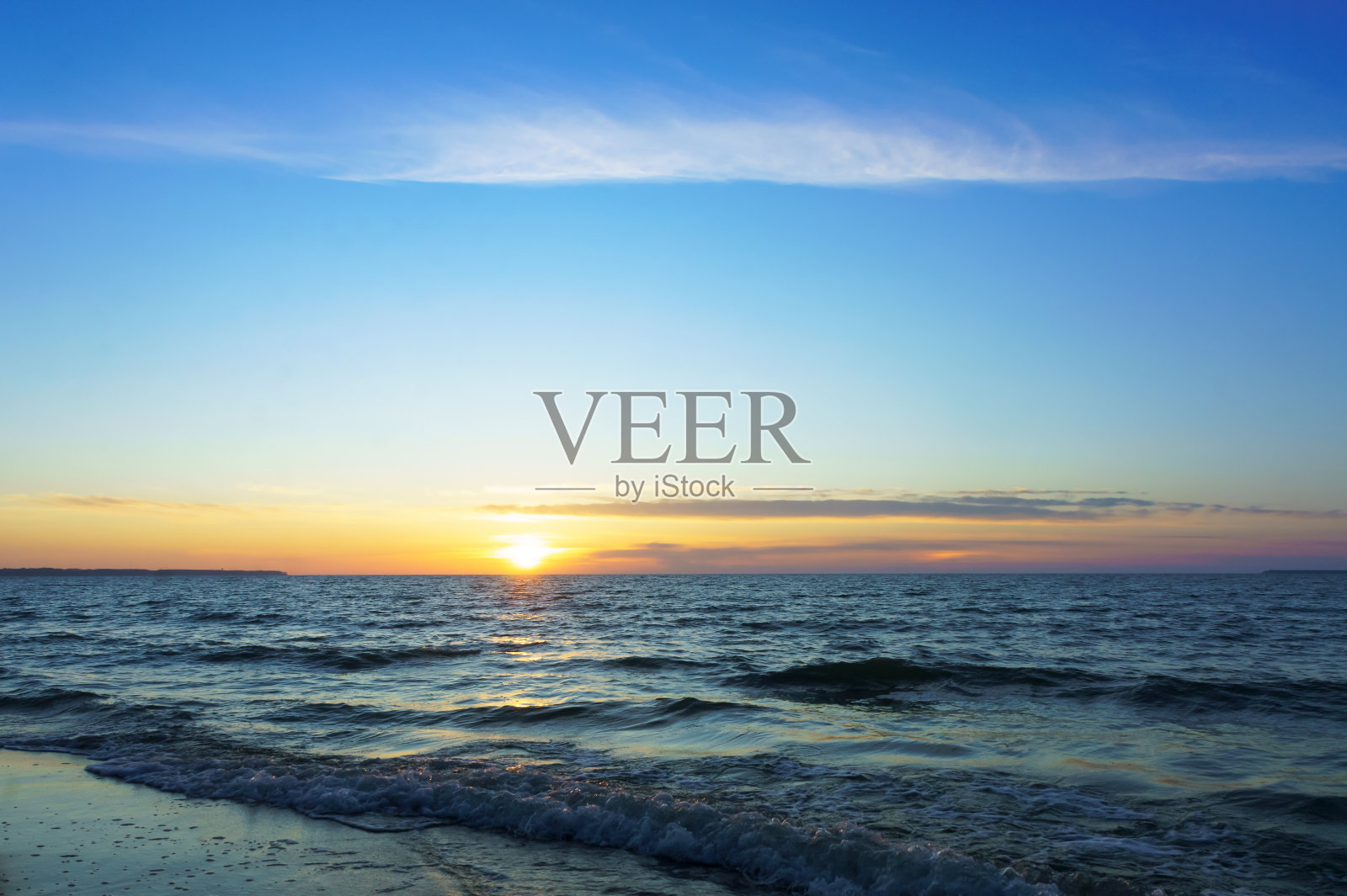 海岸上的日落，太阳落到地平线以下照片摄影图片