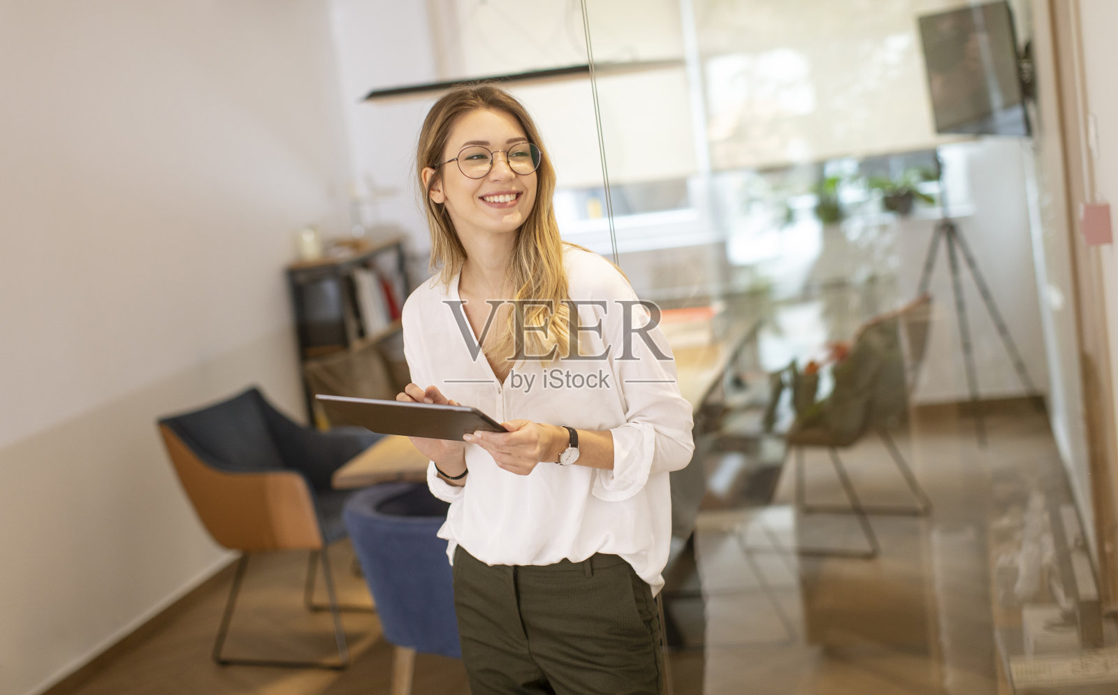 在办公室里用平板电脑工作的年轻女性照片摄影图片